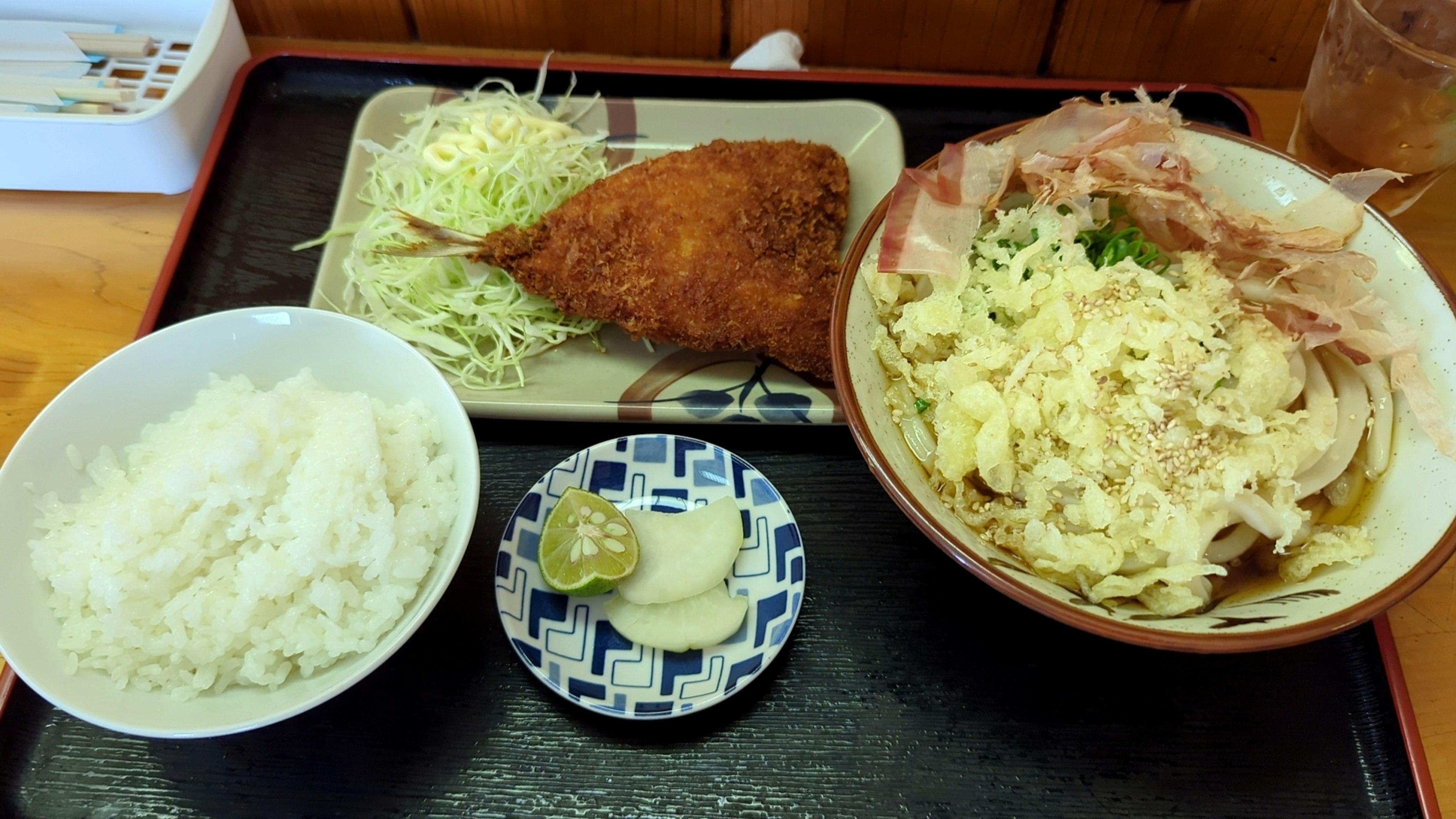 一份日式餐點包含米飯、捲心菜、炸餅和蛋碗在托盤上