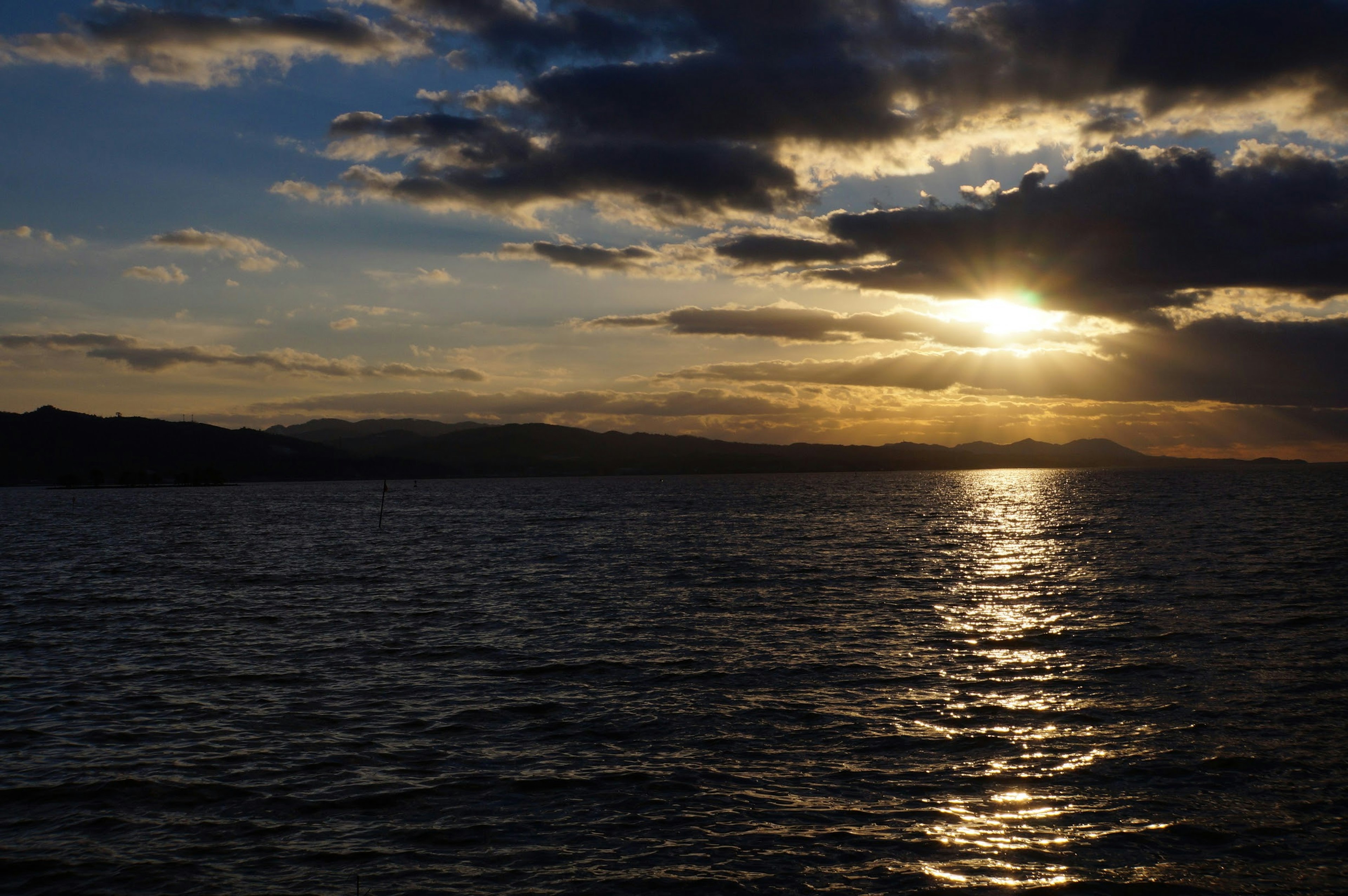 Schöne Landschaft mit Sonnenuntergang, der sich im Meer spiegelt