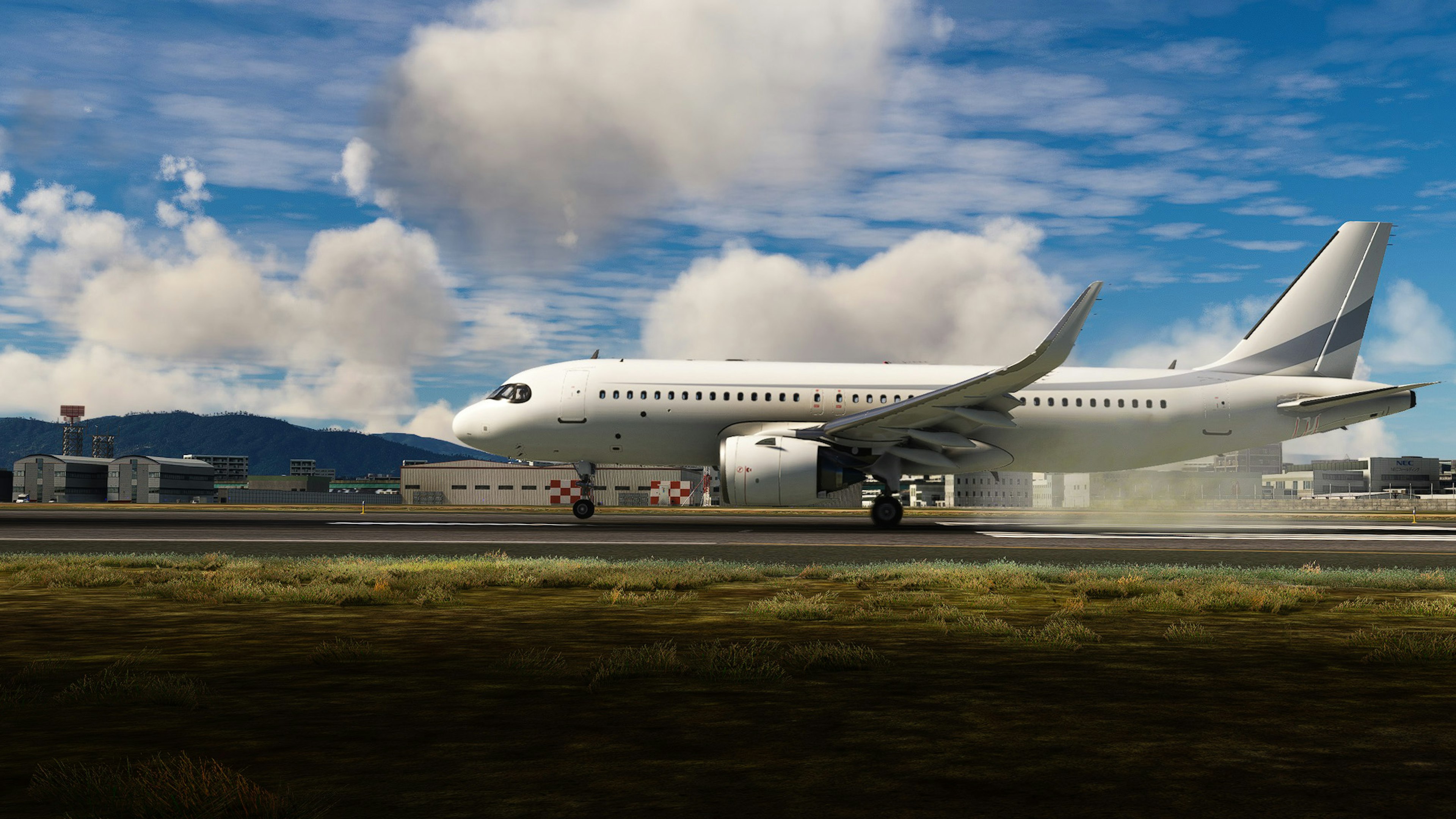 A white passenger airplane taxiing on the runway with blue sky and clouds