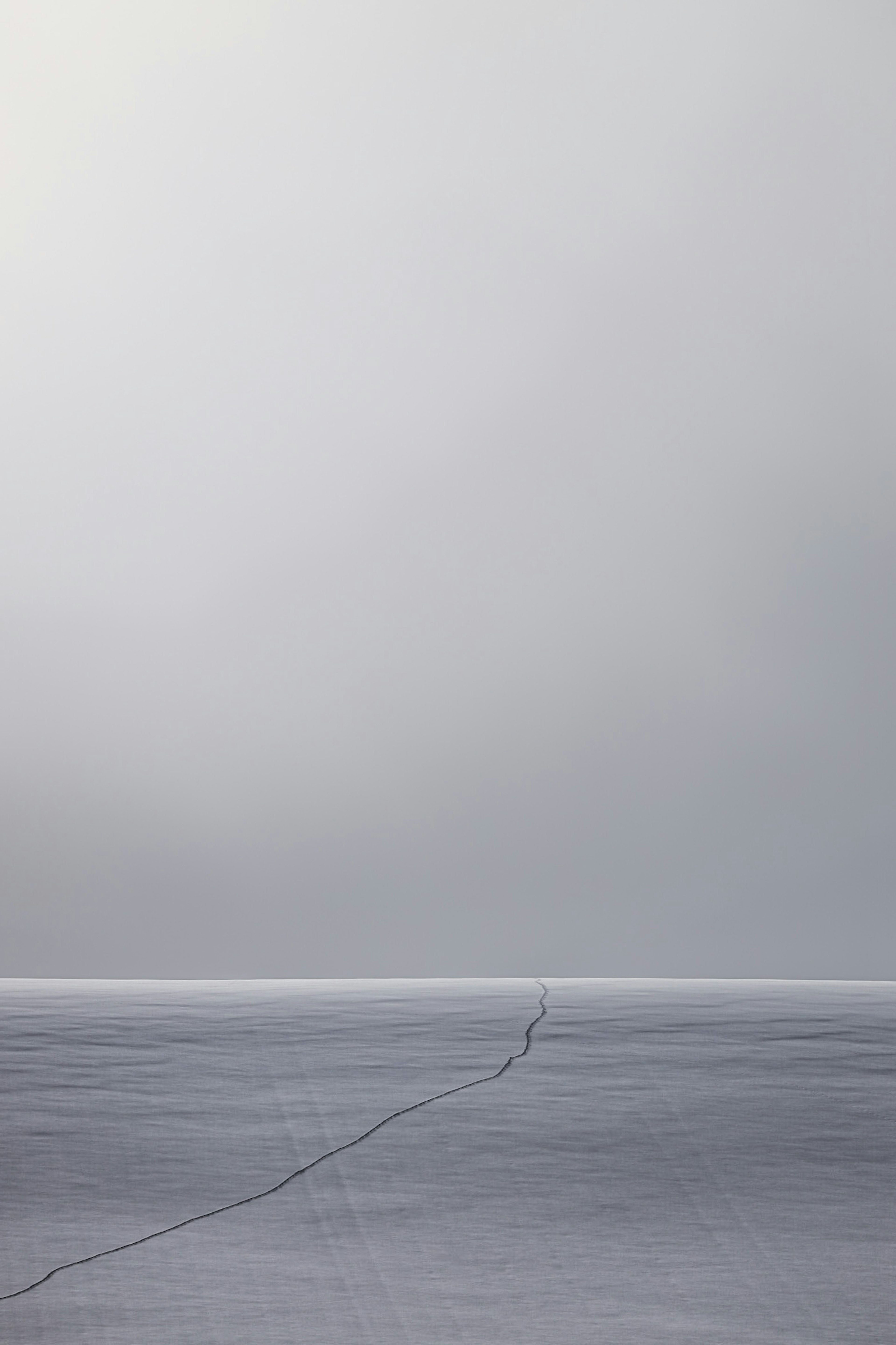 Vasto paesaggio ghiacciato nella nebbia con impronte visibili