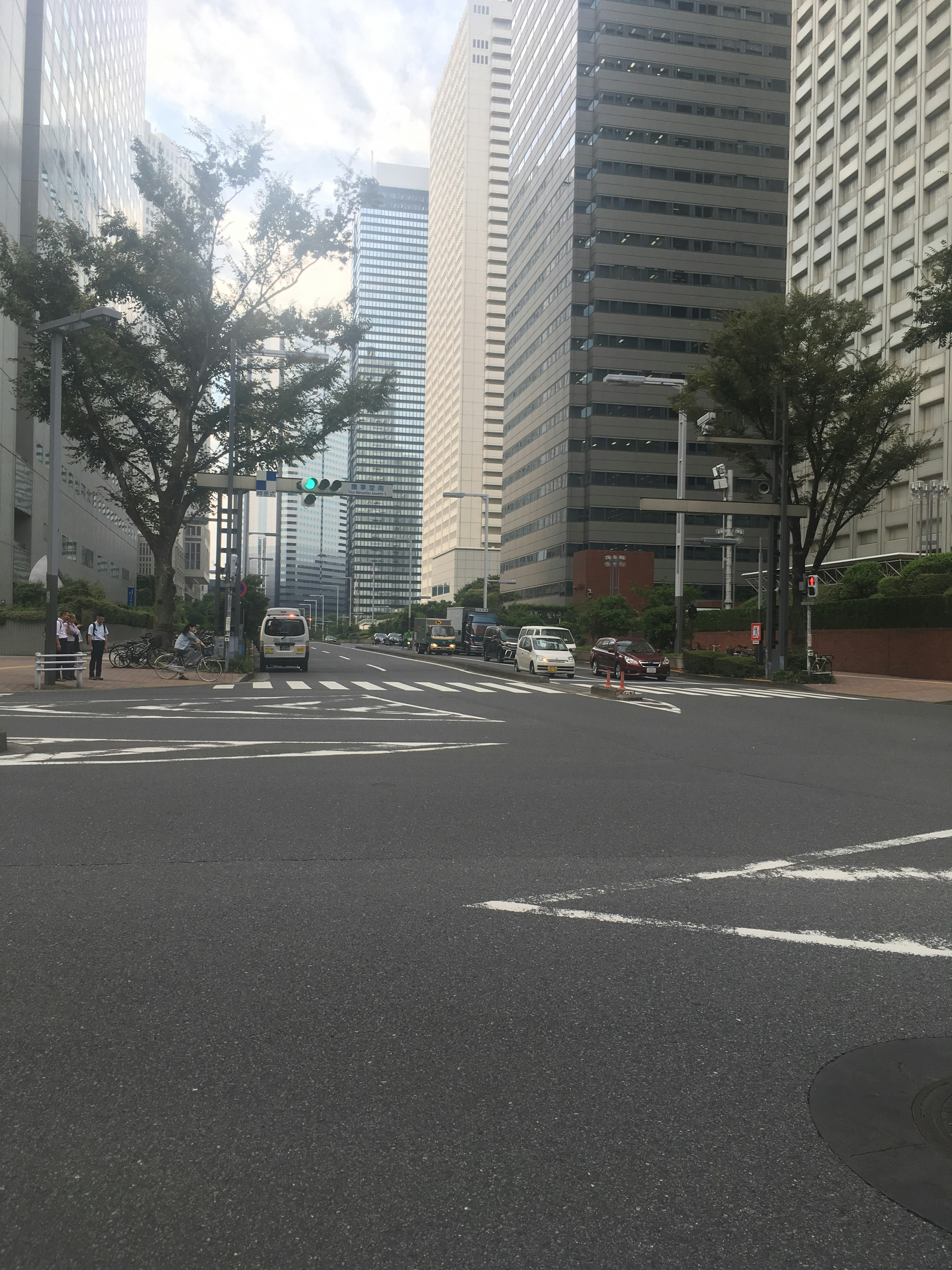 Intersection surrounded by skyscrapers with blue sky and clouds