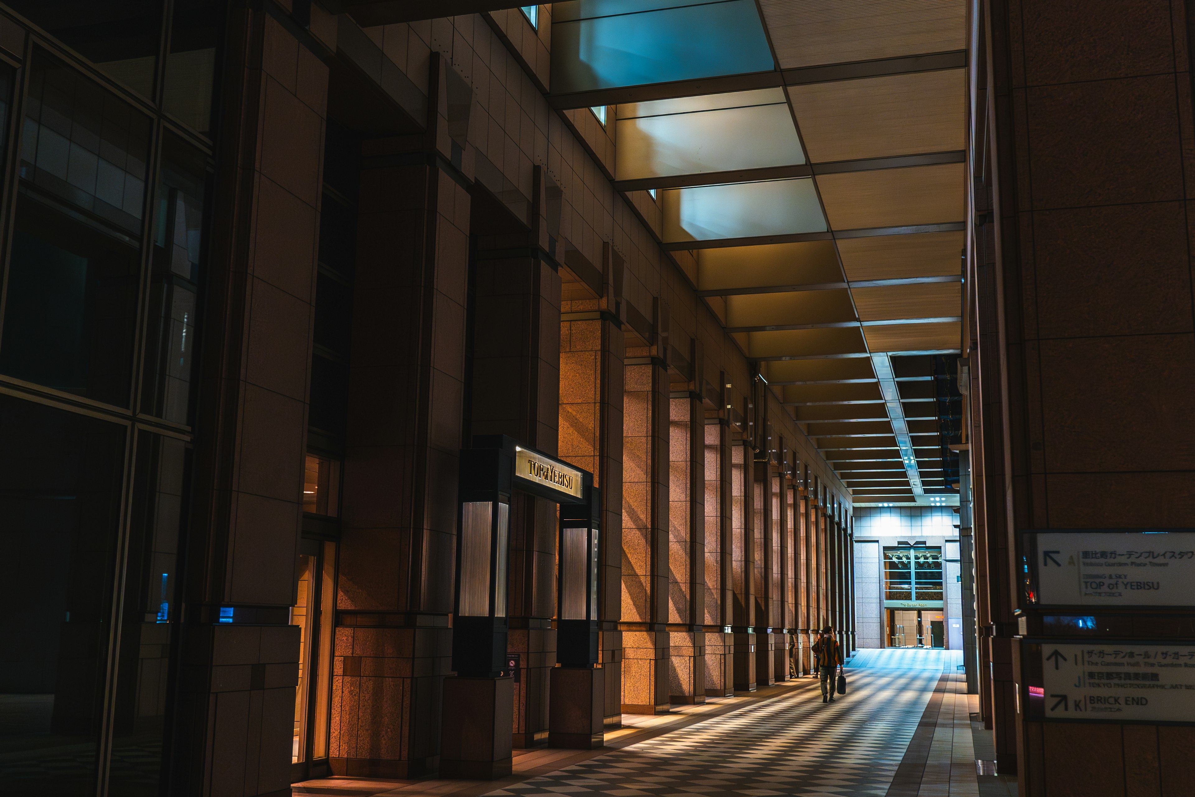 Corridoio moderno di un edificio con illuminazione brillante e lunghe ombre