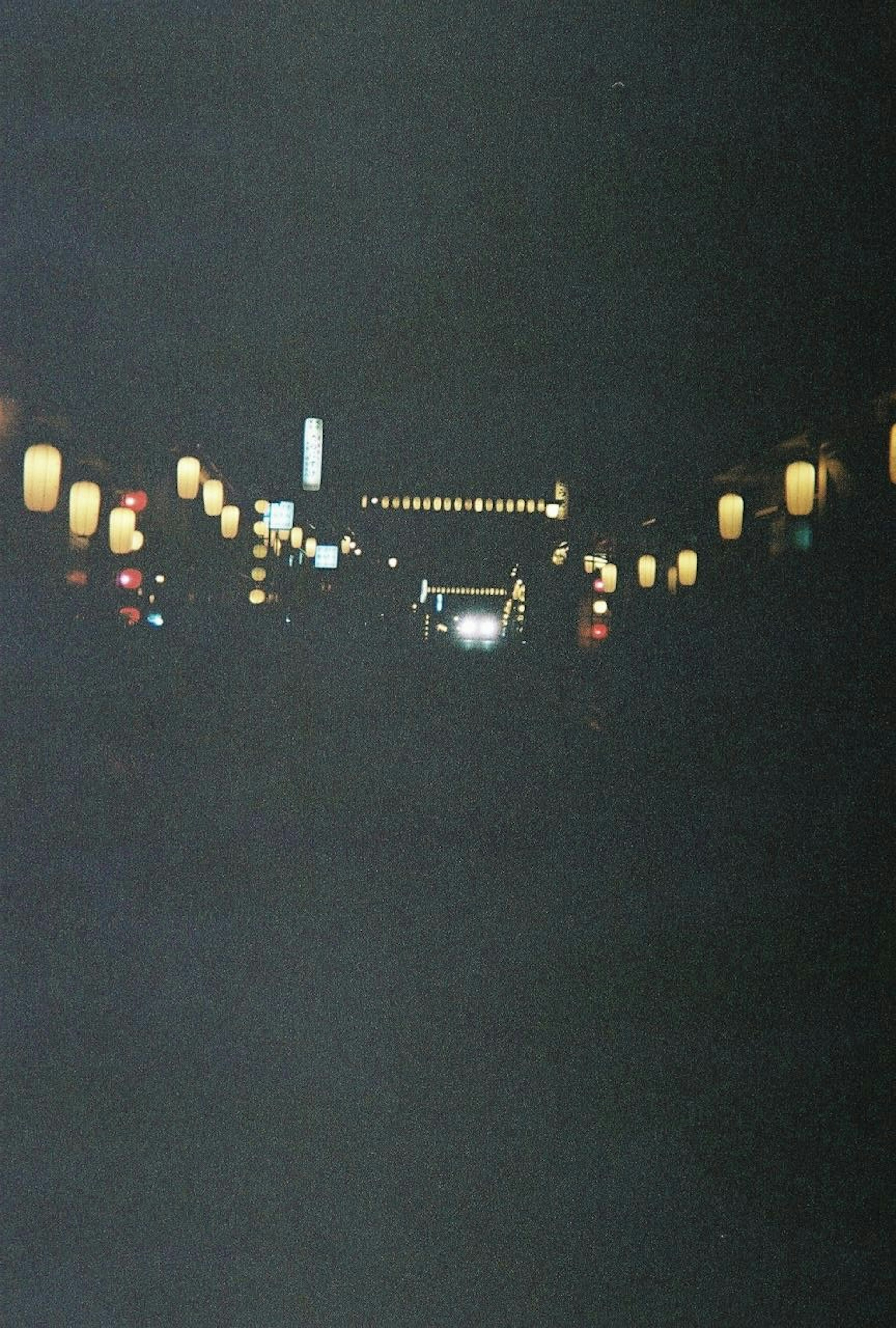 A row of lanterns illuminating a dark street at night