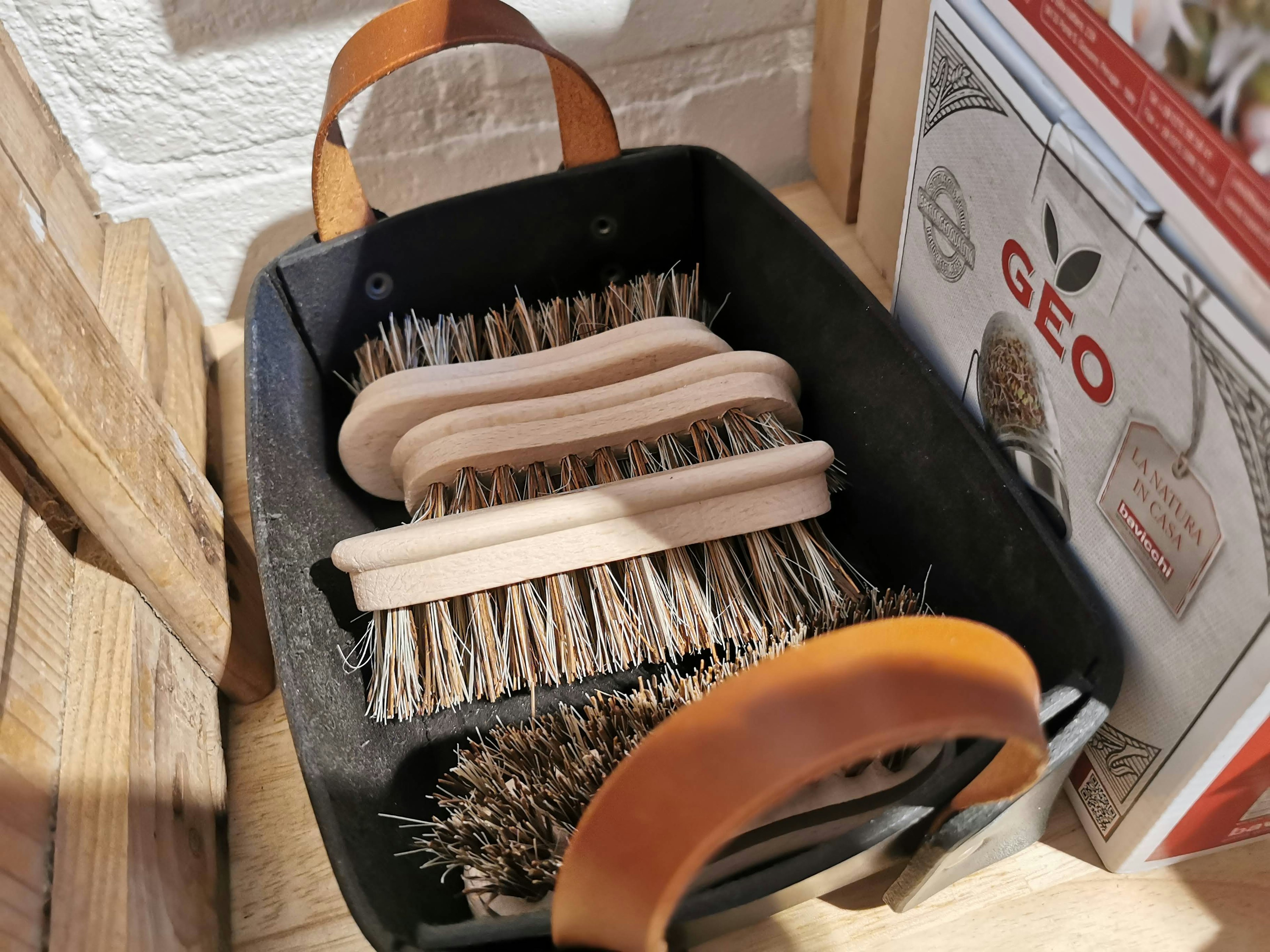 A black container with several brushes and wooden handles inside