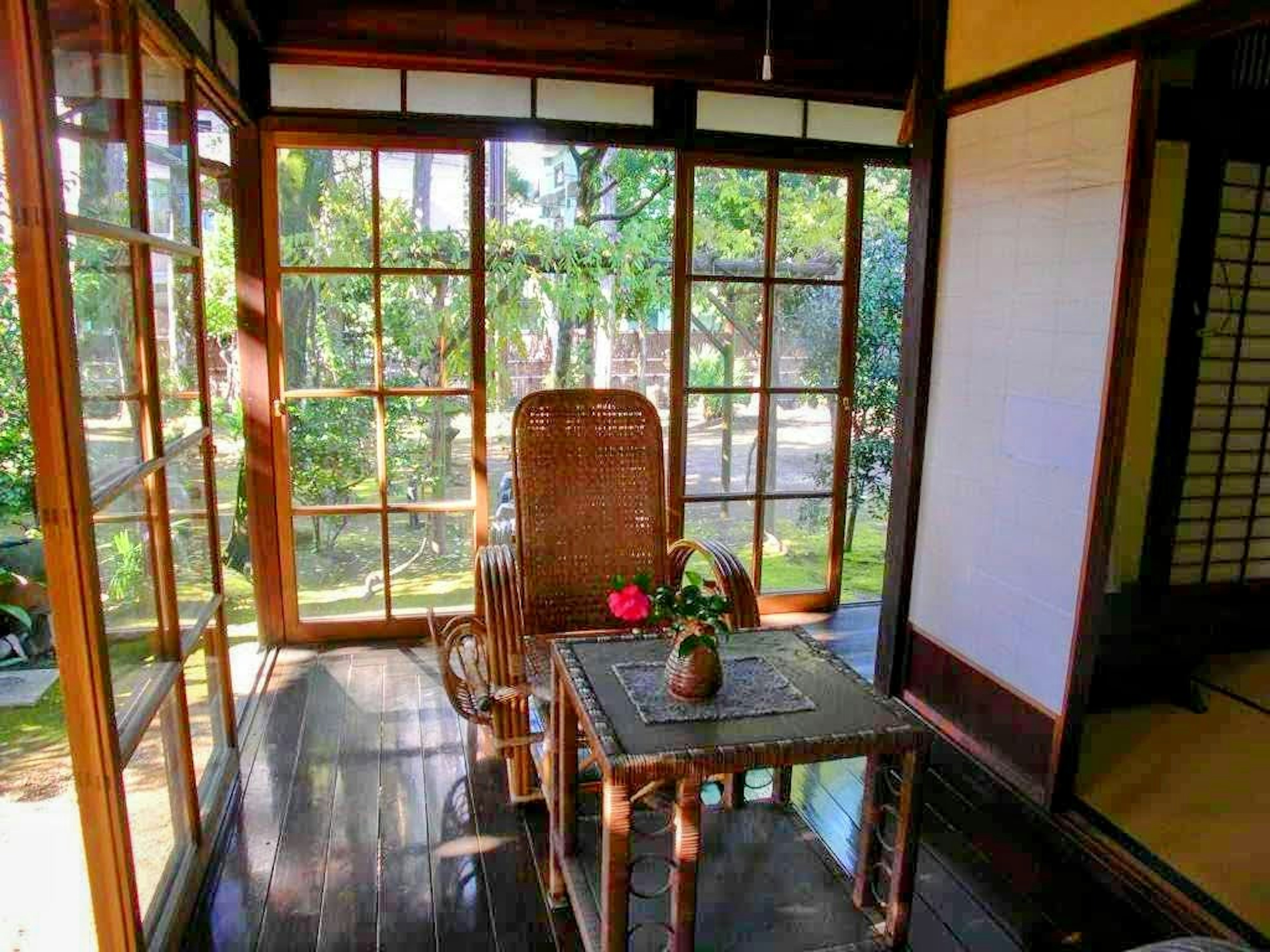 Habitación de estilo japonés con silla y mesa de madera con vistas a la vegetación