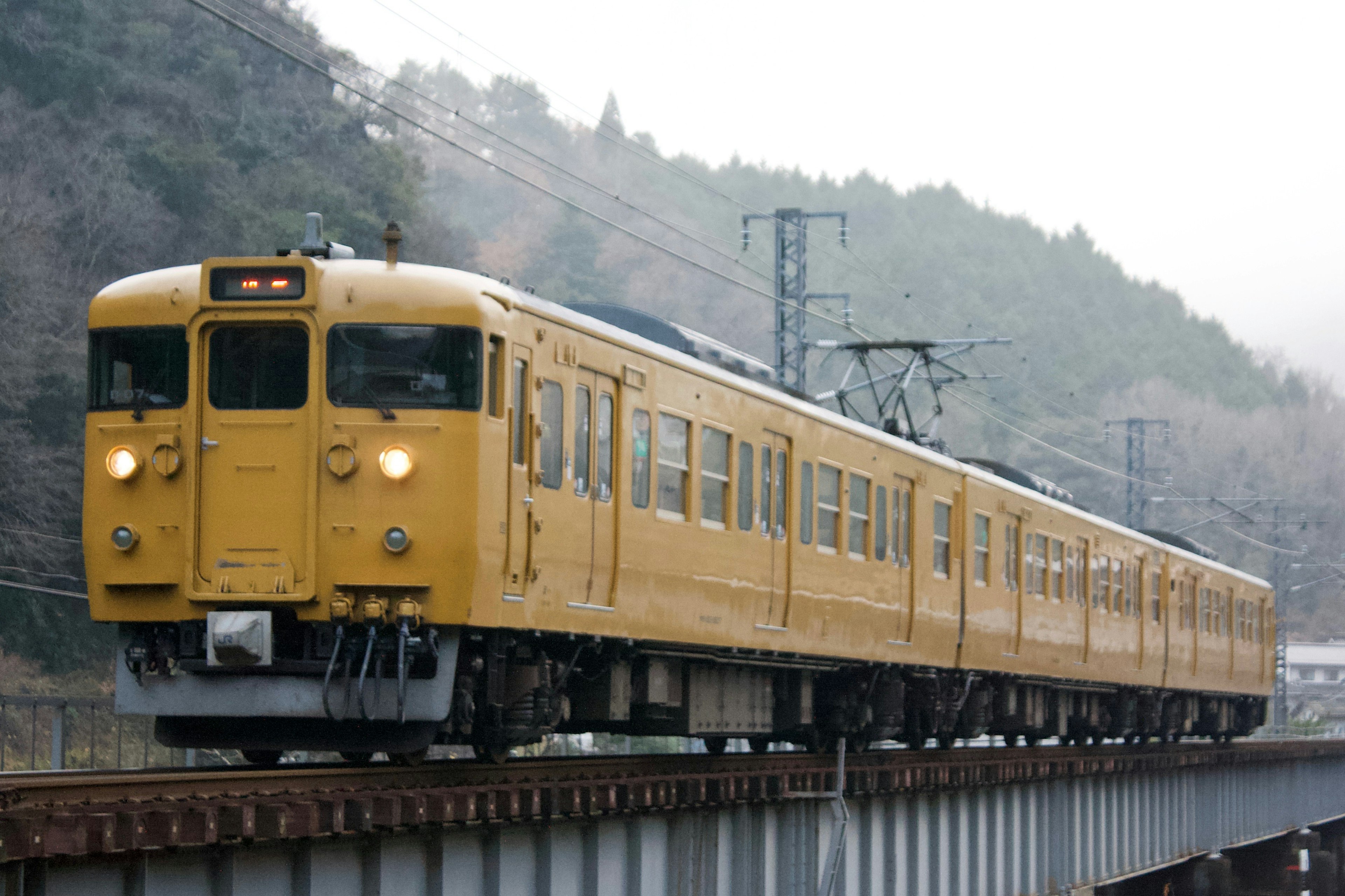 黄色い電車が線路を走る風景