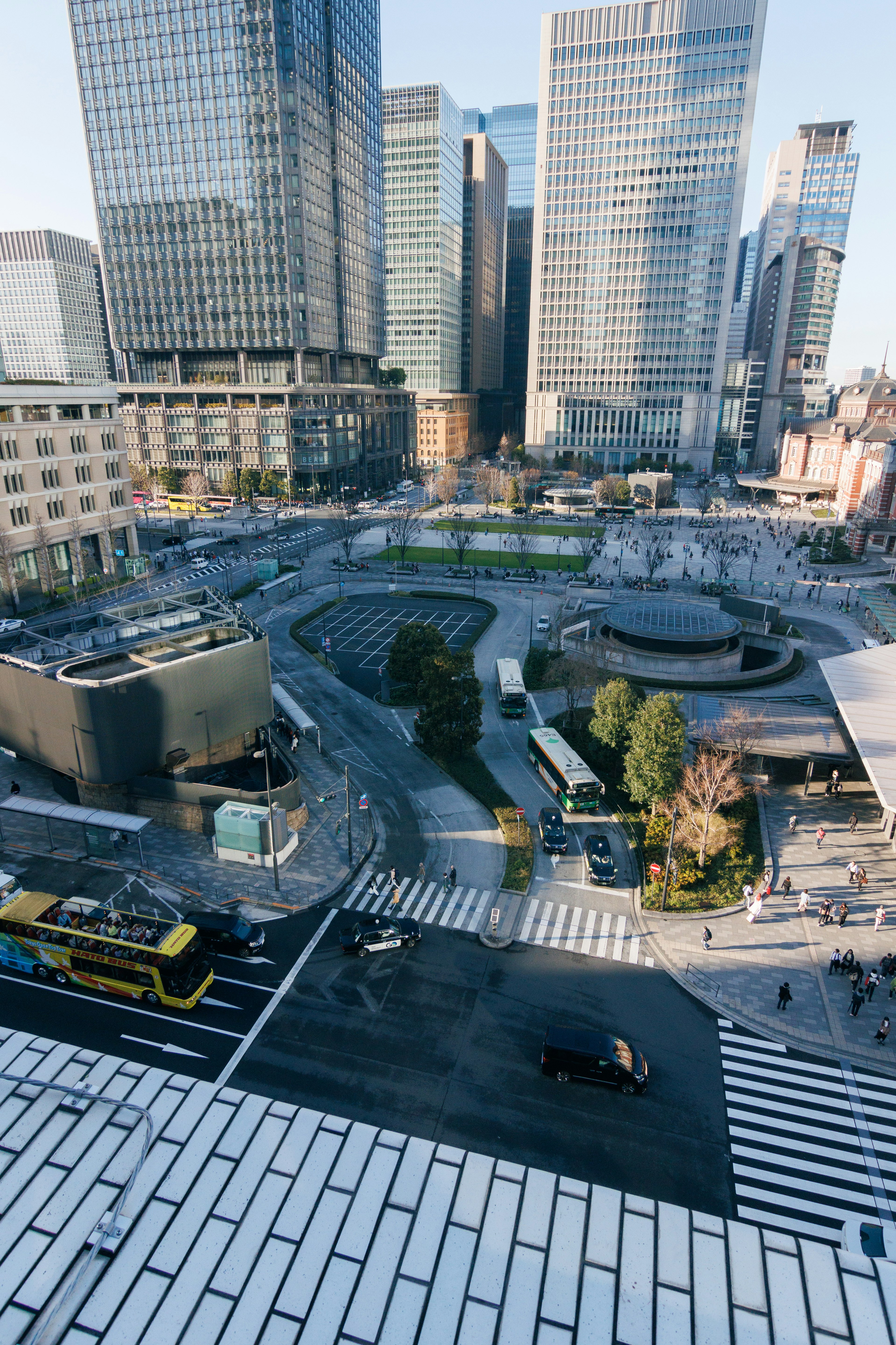 Aerial view of skyscrapers featuring a roundabout and green spaces