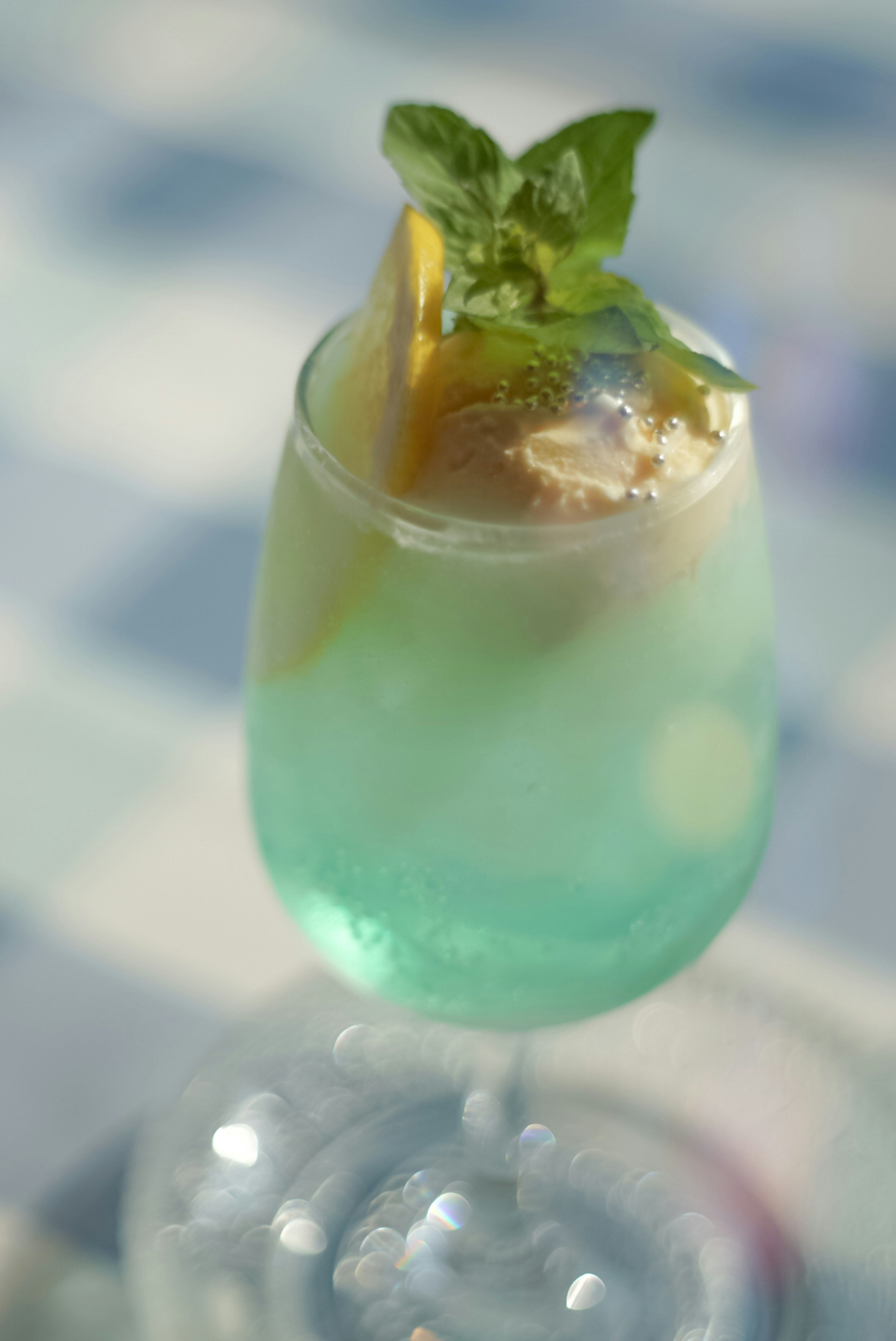 Un cocktail bleu garni de citron et de feuilles de menthe dans un verre