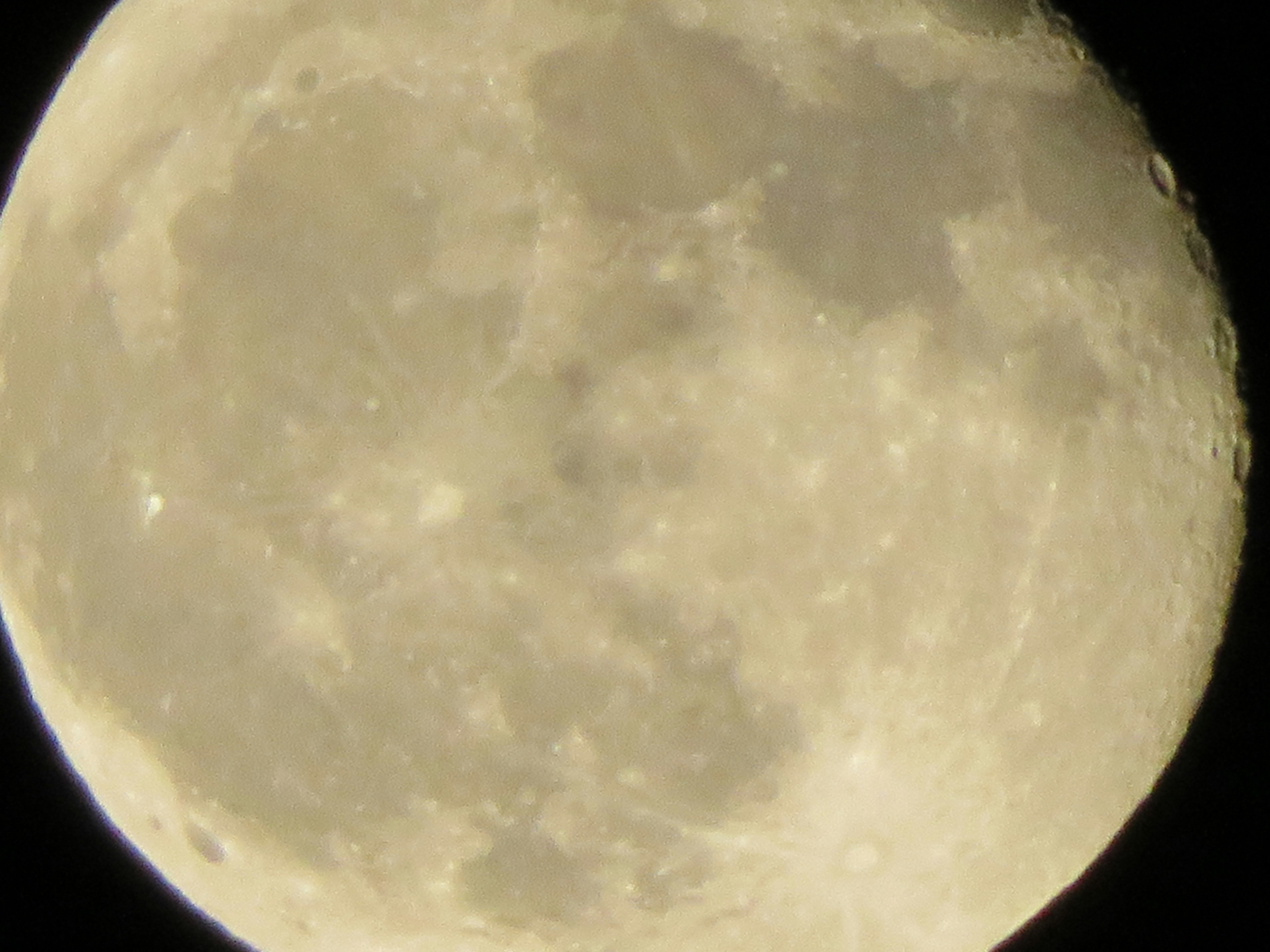 Close-up of the moon showing bright hues and surface craters