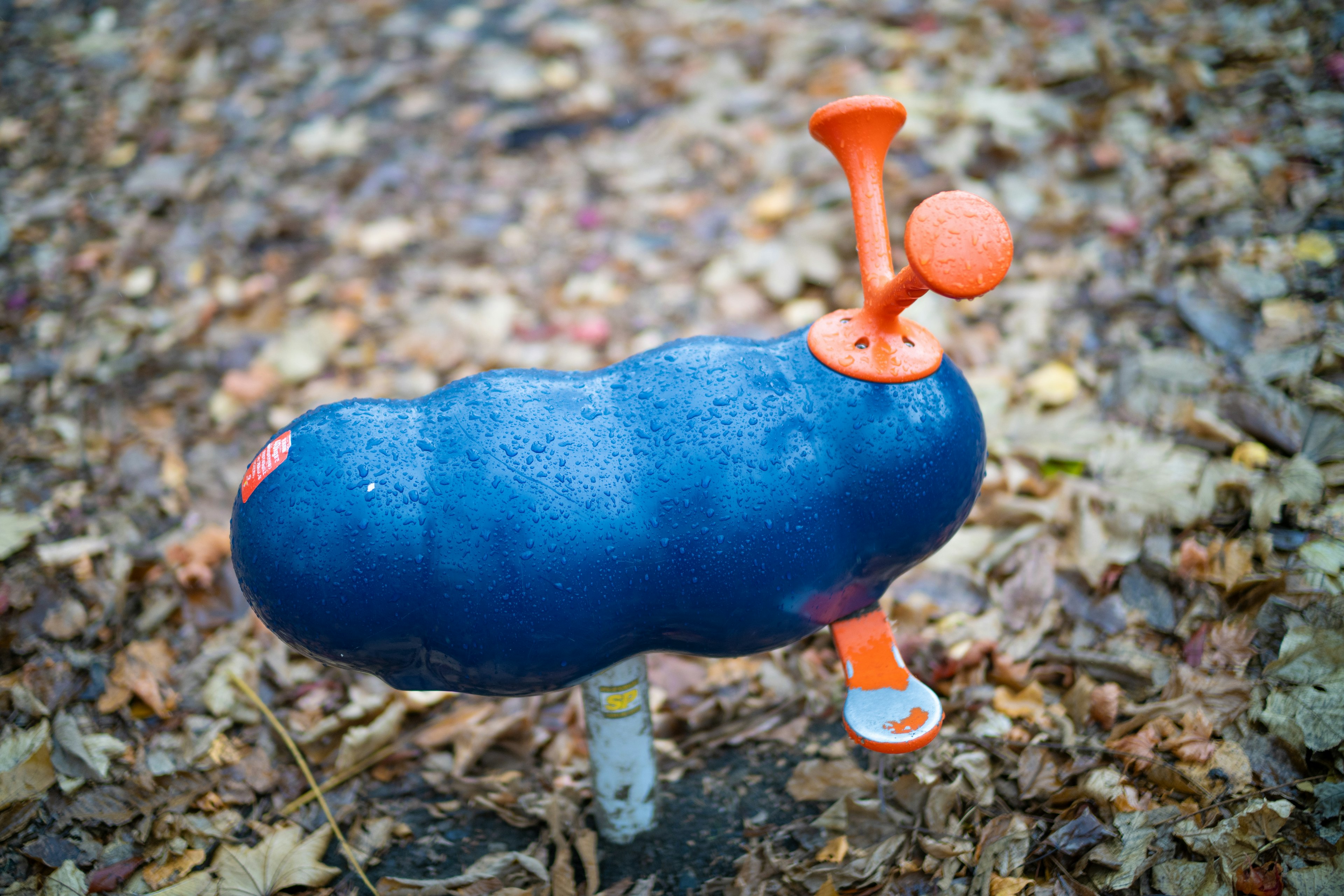 Blue object resembling a slug with orange horn and base