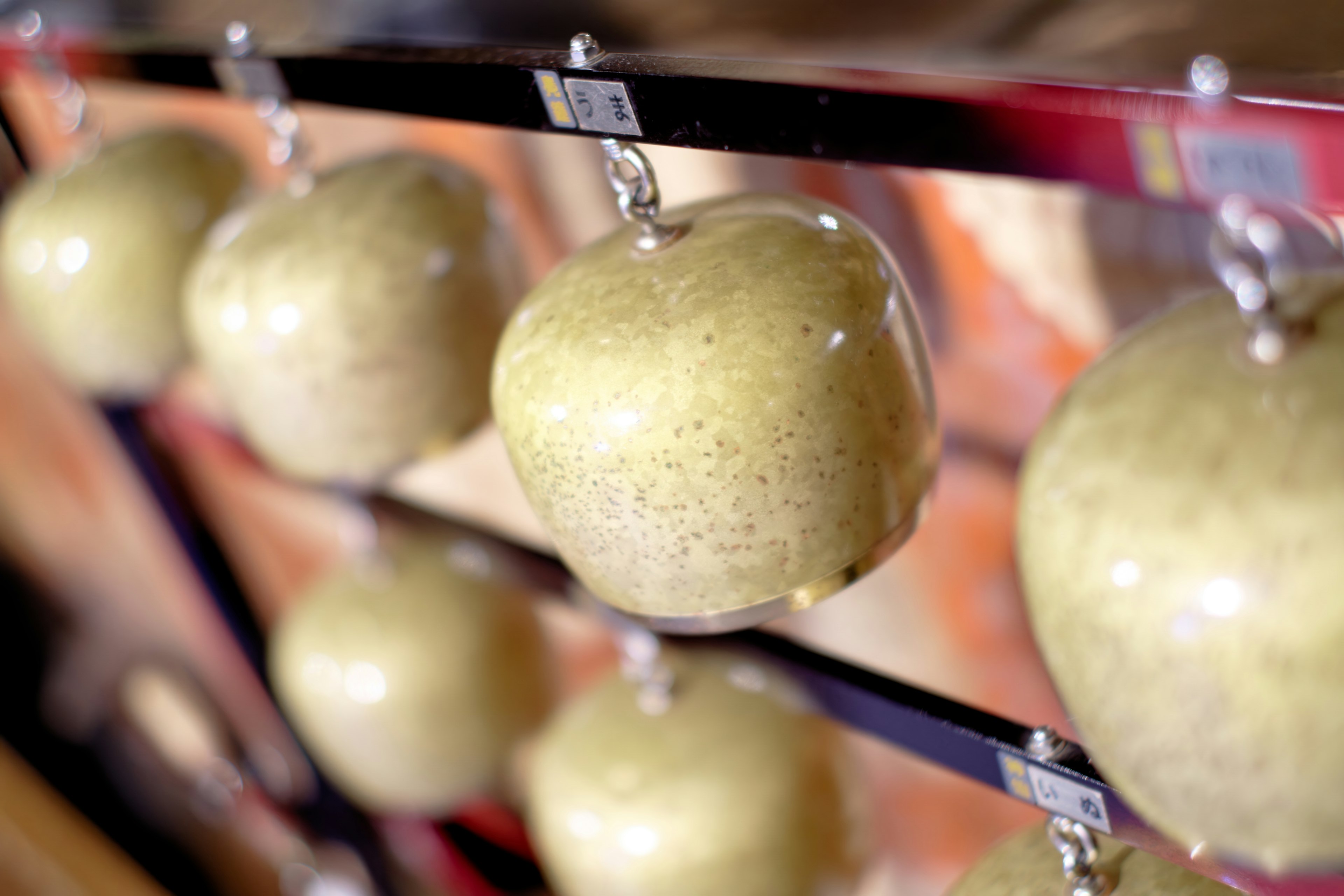 Display of green apples hanging in a row