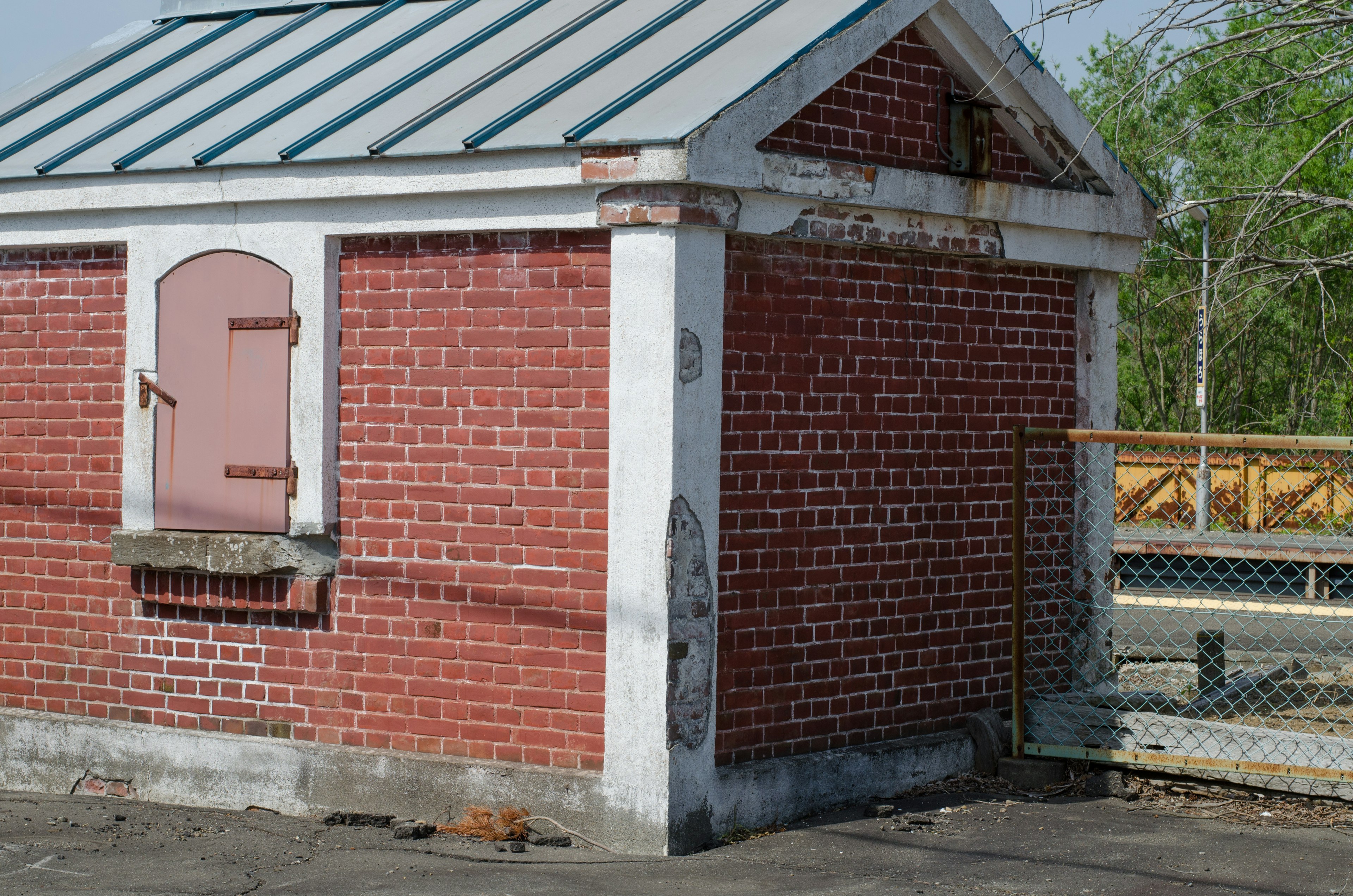 Bâtiment en briques rouges avec un toit en métal et des caractéristiques distinctives