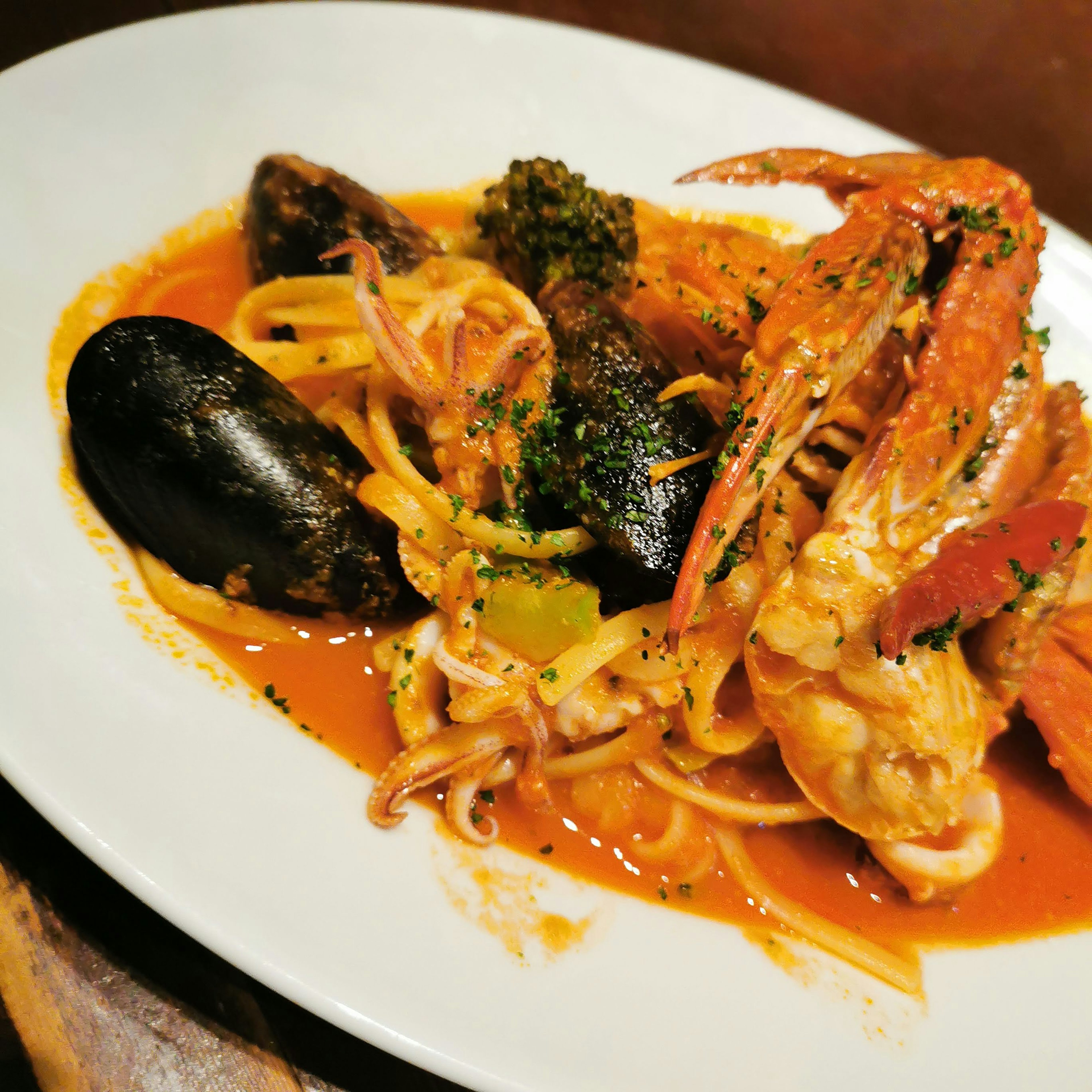 Un plato de pasta de mariscos con camarones, mejillones y brócoli