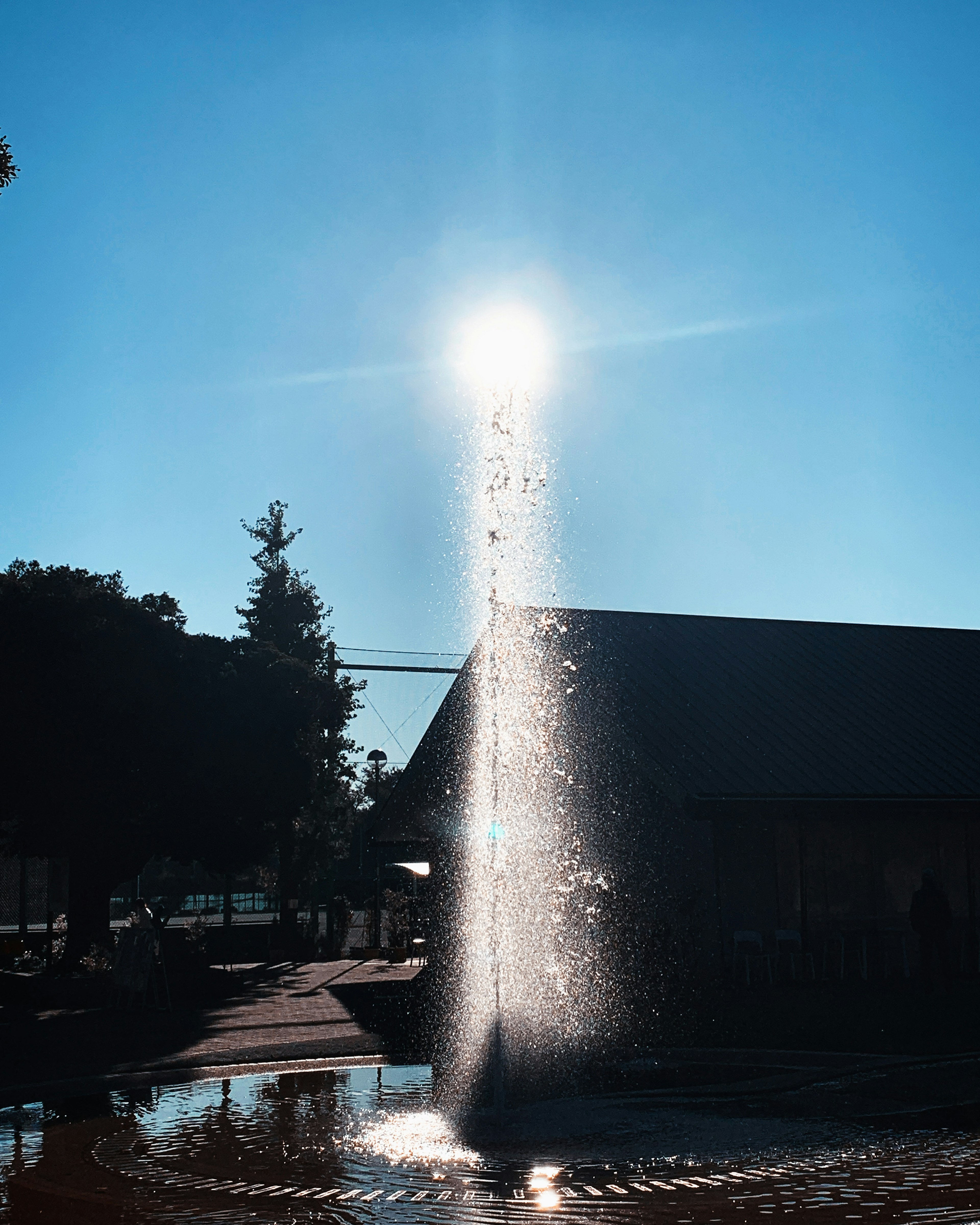 Fuente rociando agua bajo un cielo azul claro