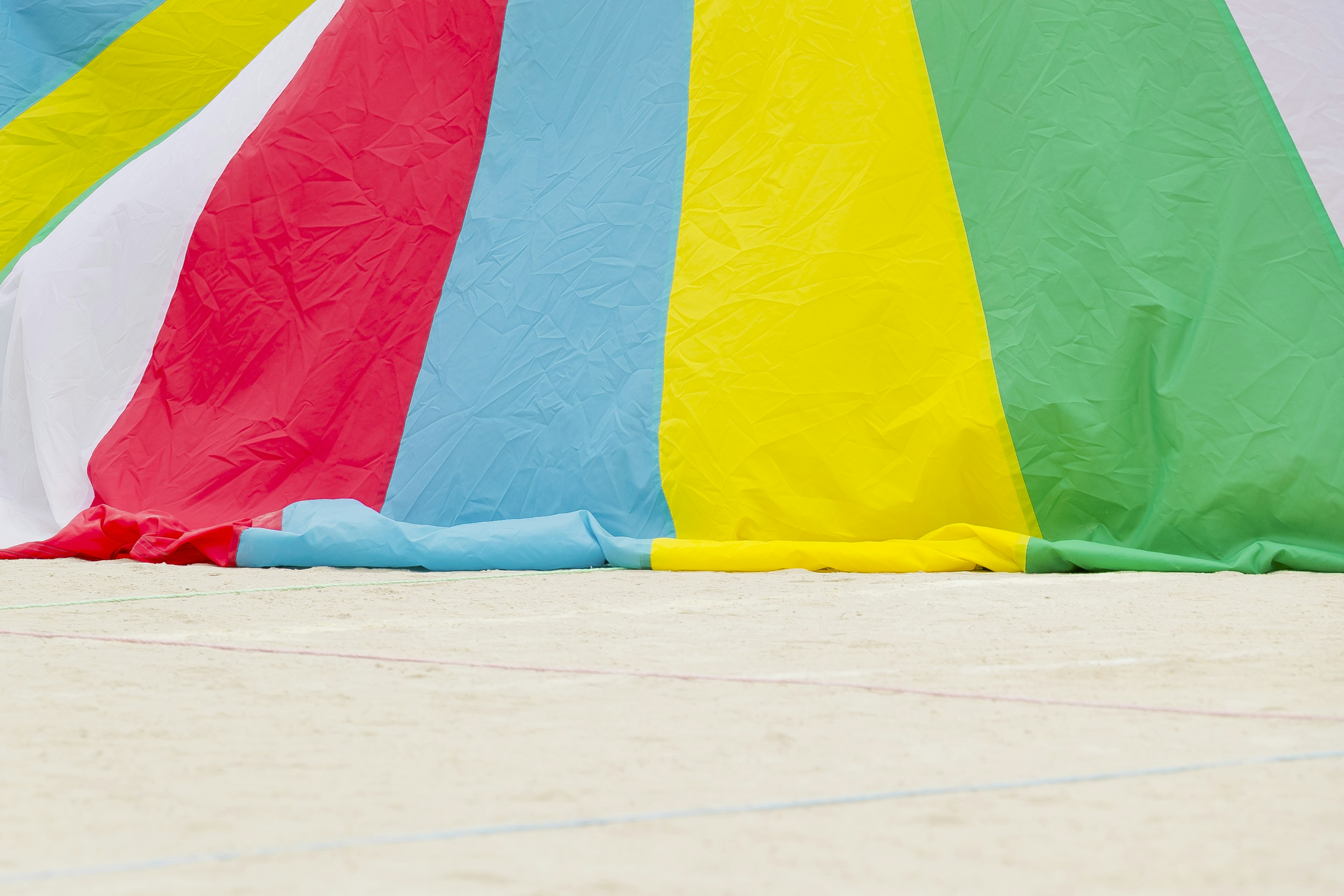 Bunte Stoffe hängen an einem Sandstrand