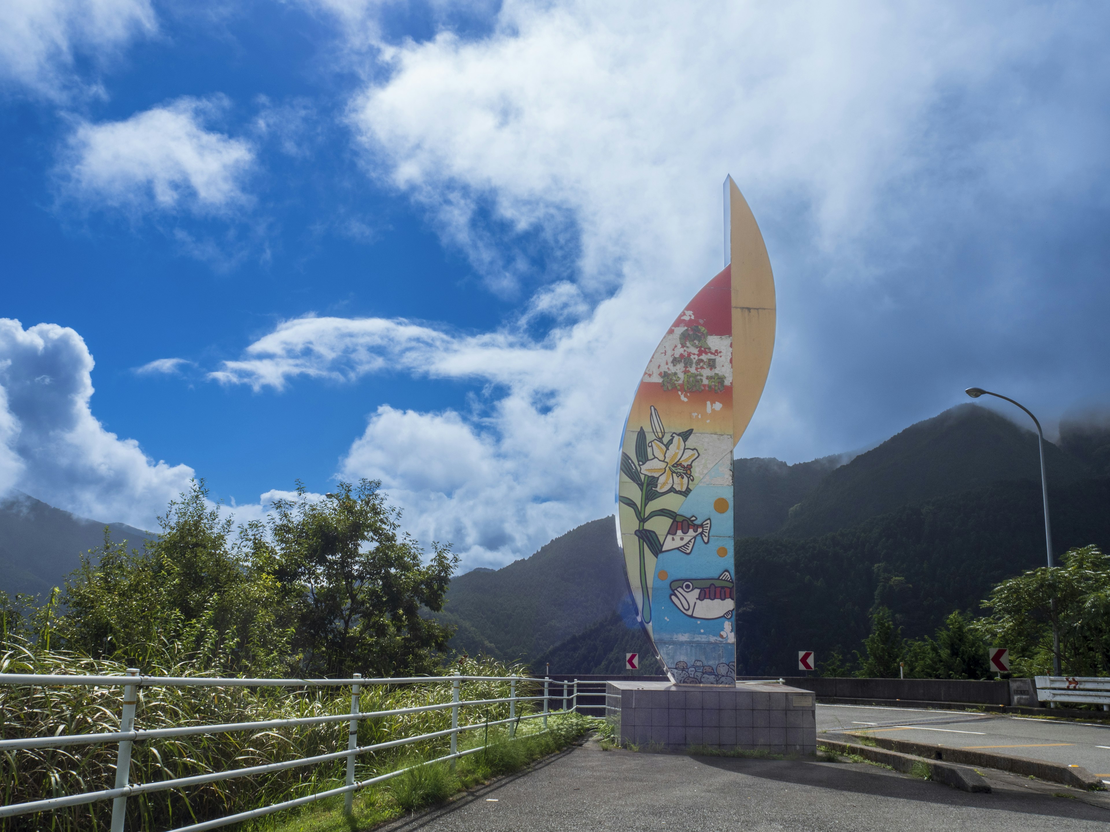 青空と山々を背景にしたカラフルなモニュメント