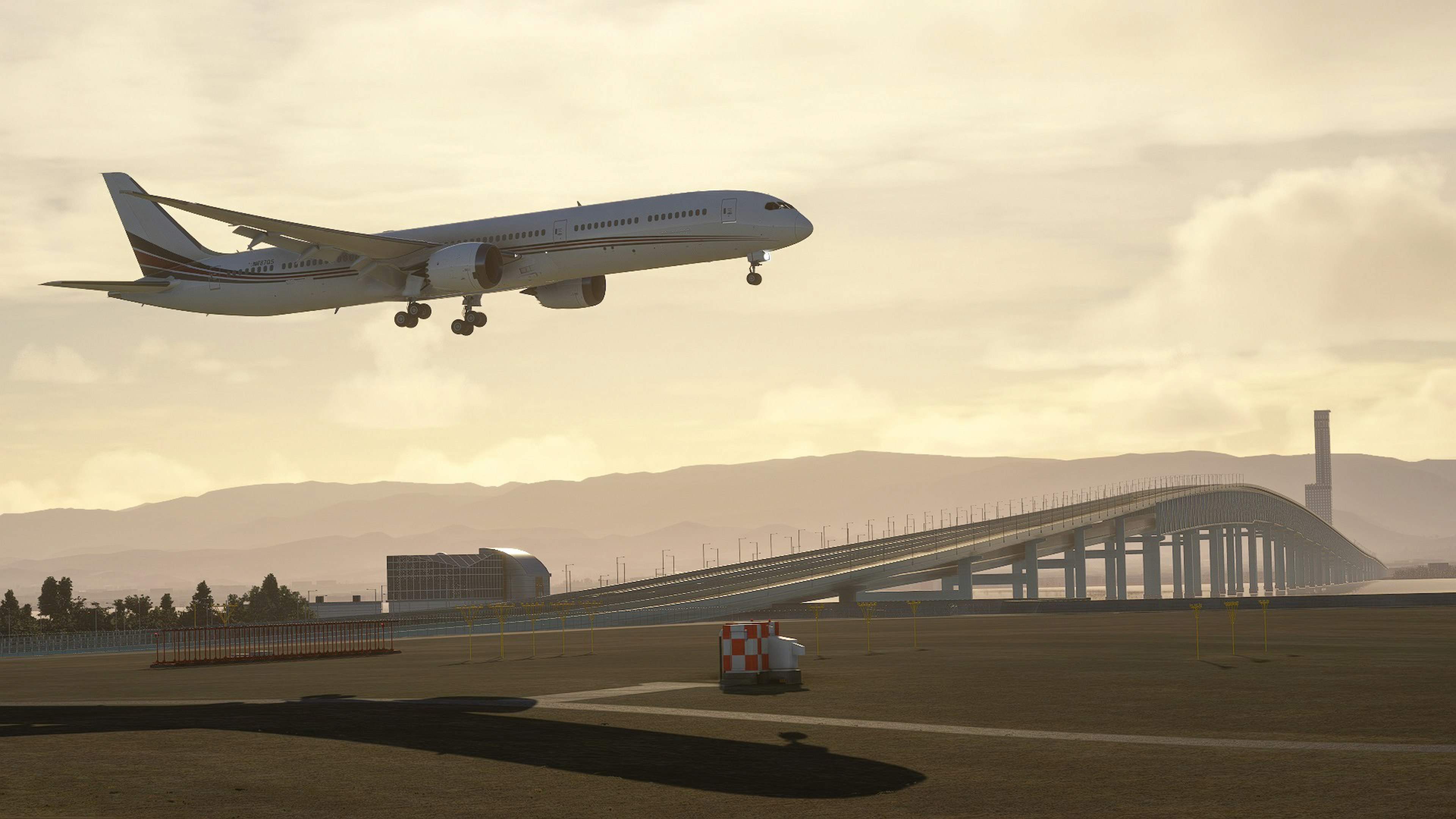 Airplane landing during sunset with bridge in background