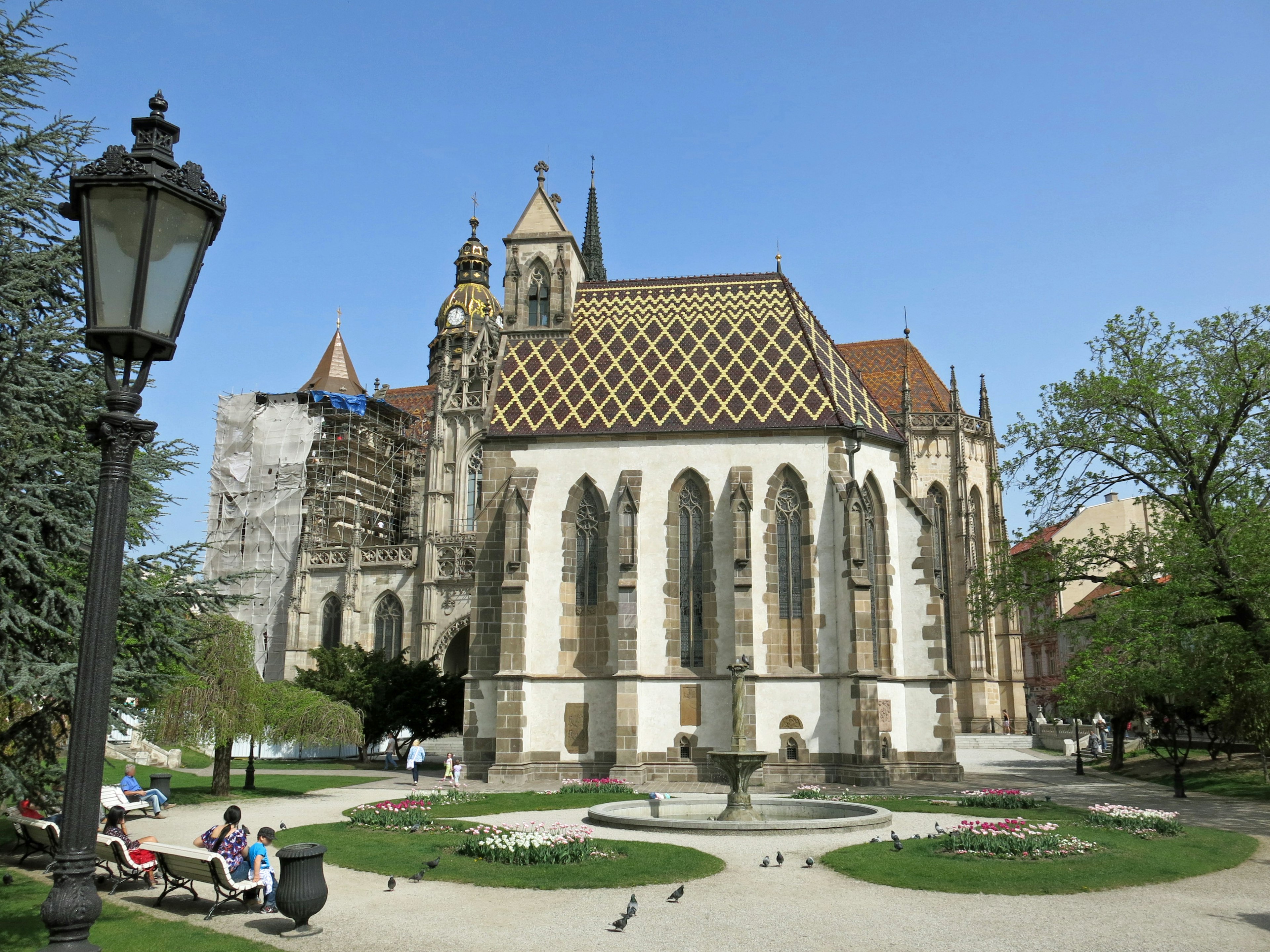 Extérieur d'une église imposante dans un beau parc avec une architecture gothique distinctive et une façade décorative