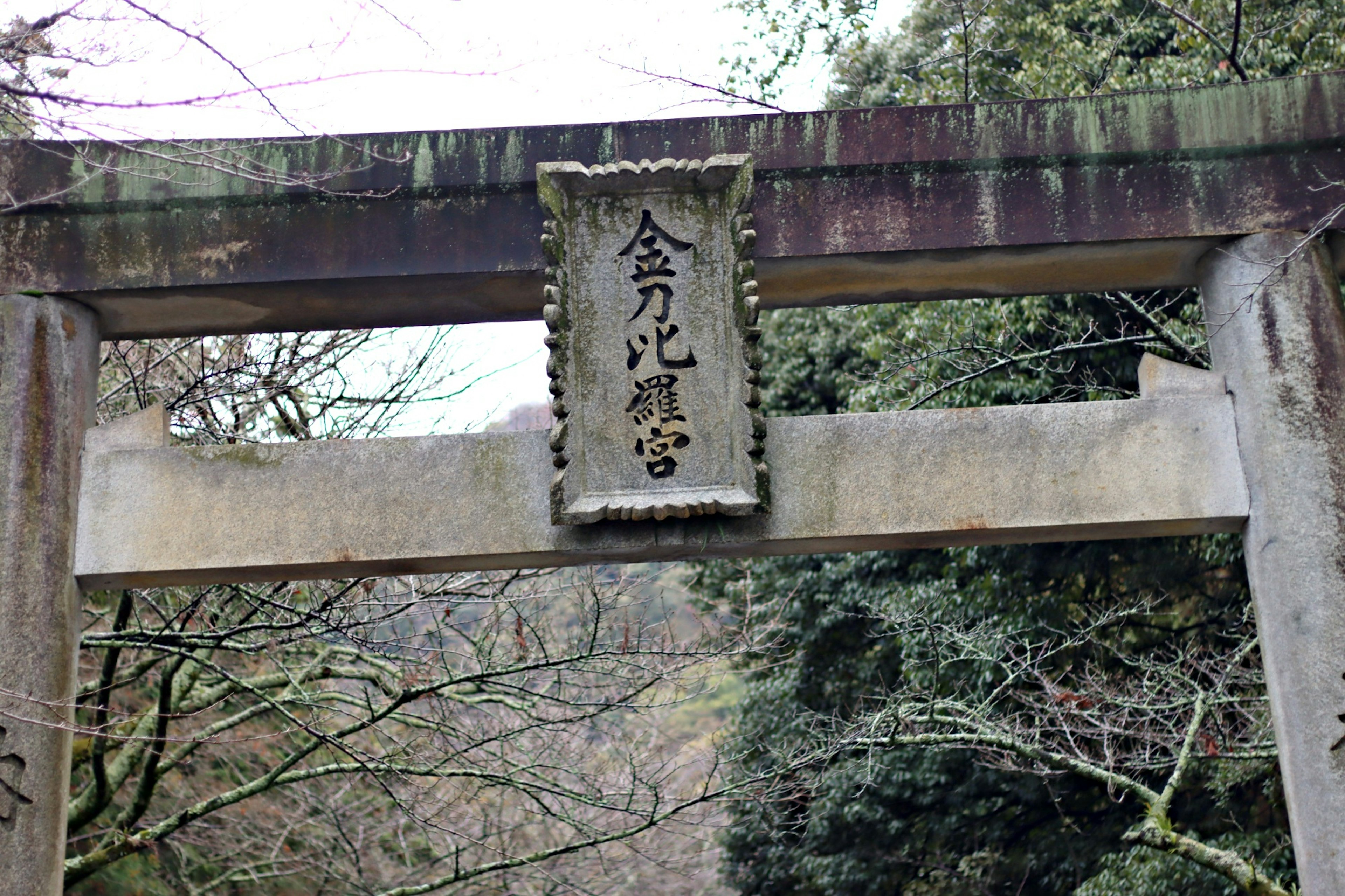 Un antico torii con un'iscrizione su una placca di pietra