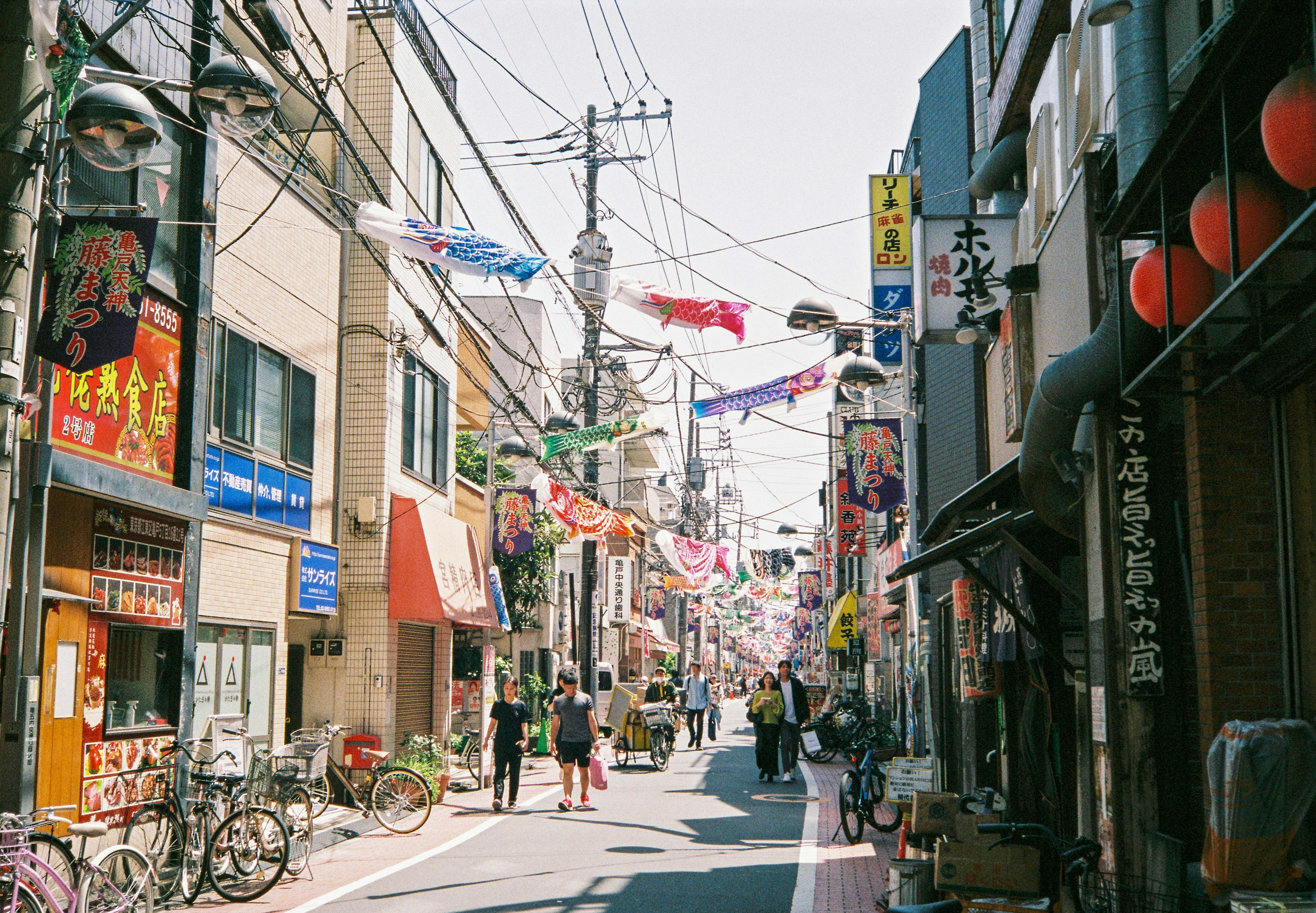 Escena de calle bulliciosa en Japón con personas caminando en un distrito comercial