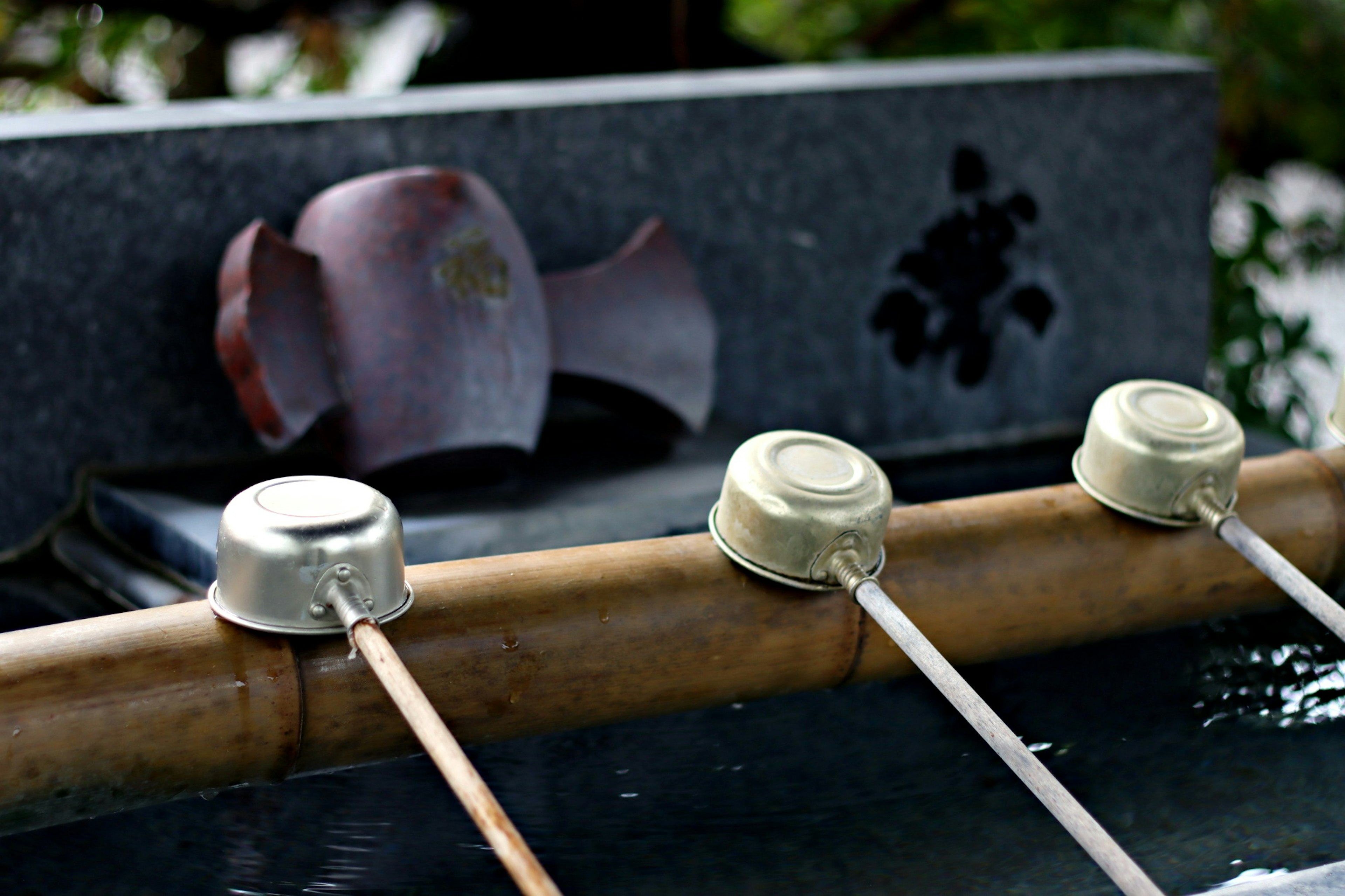 Stone water basin with metal ladles arranged beside it