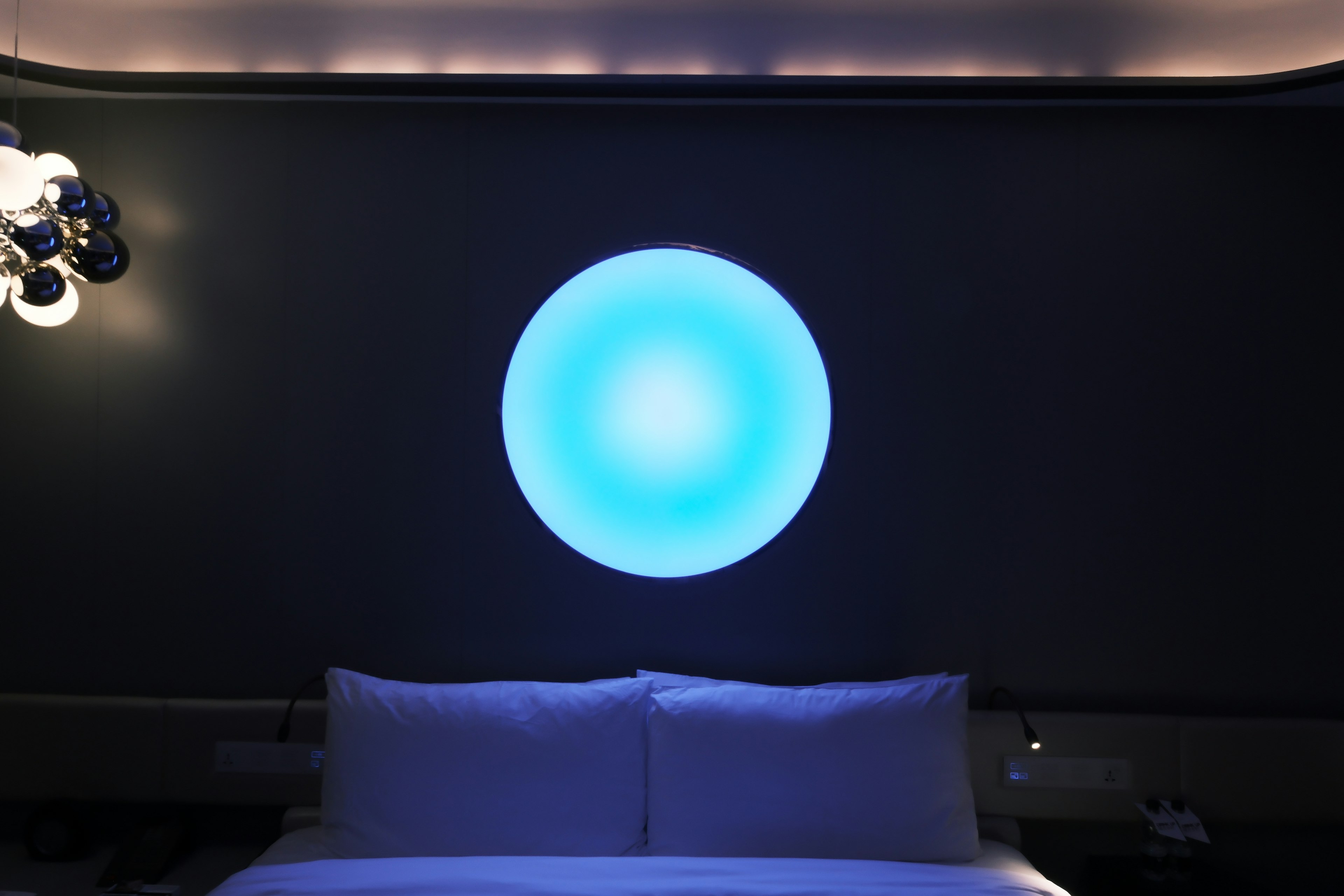 Kamar modern dengan lampu bulat biru di dinding