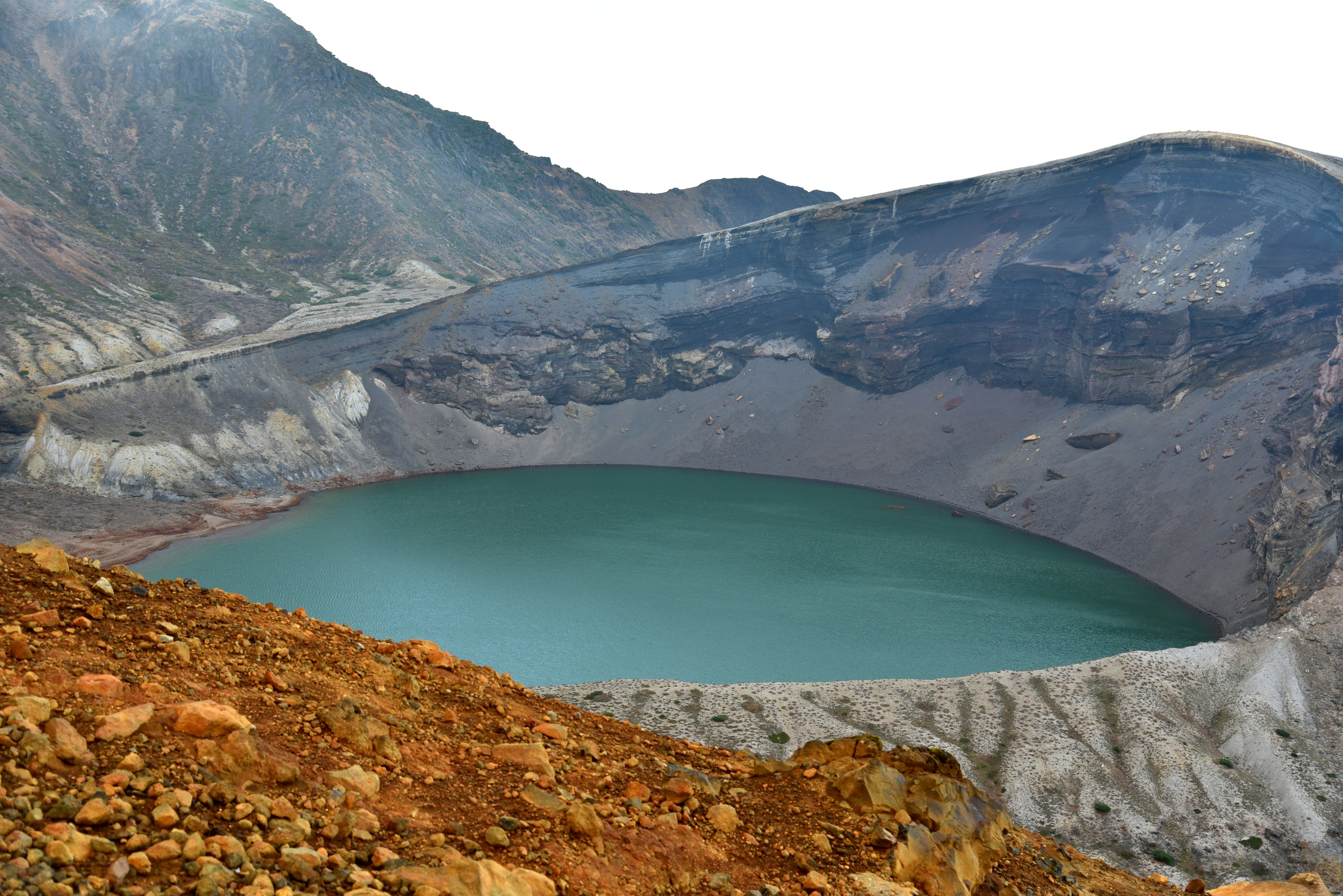 Scenic view of a volcanic crater featuring a blue lake