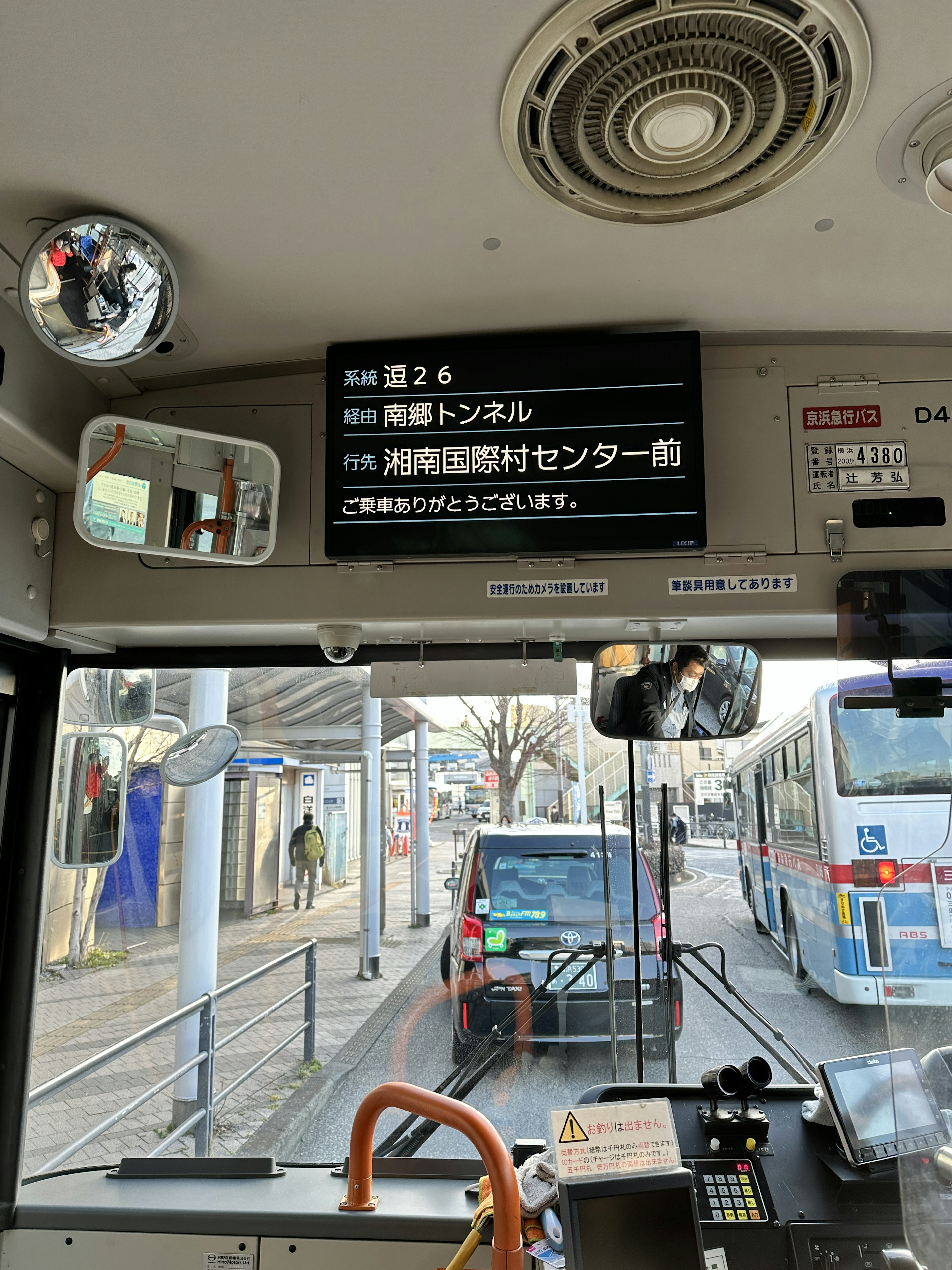 View from a bus driver's seat showing destination Aobadai Station with traffic signs and mirrors visible