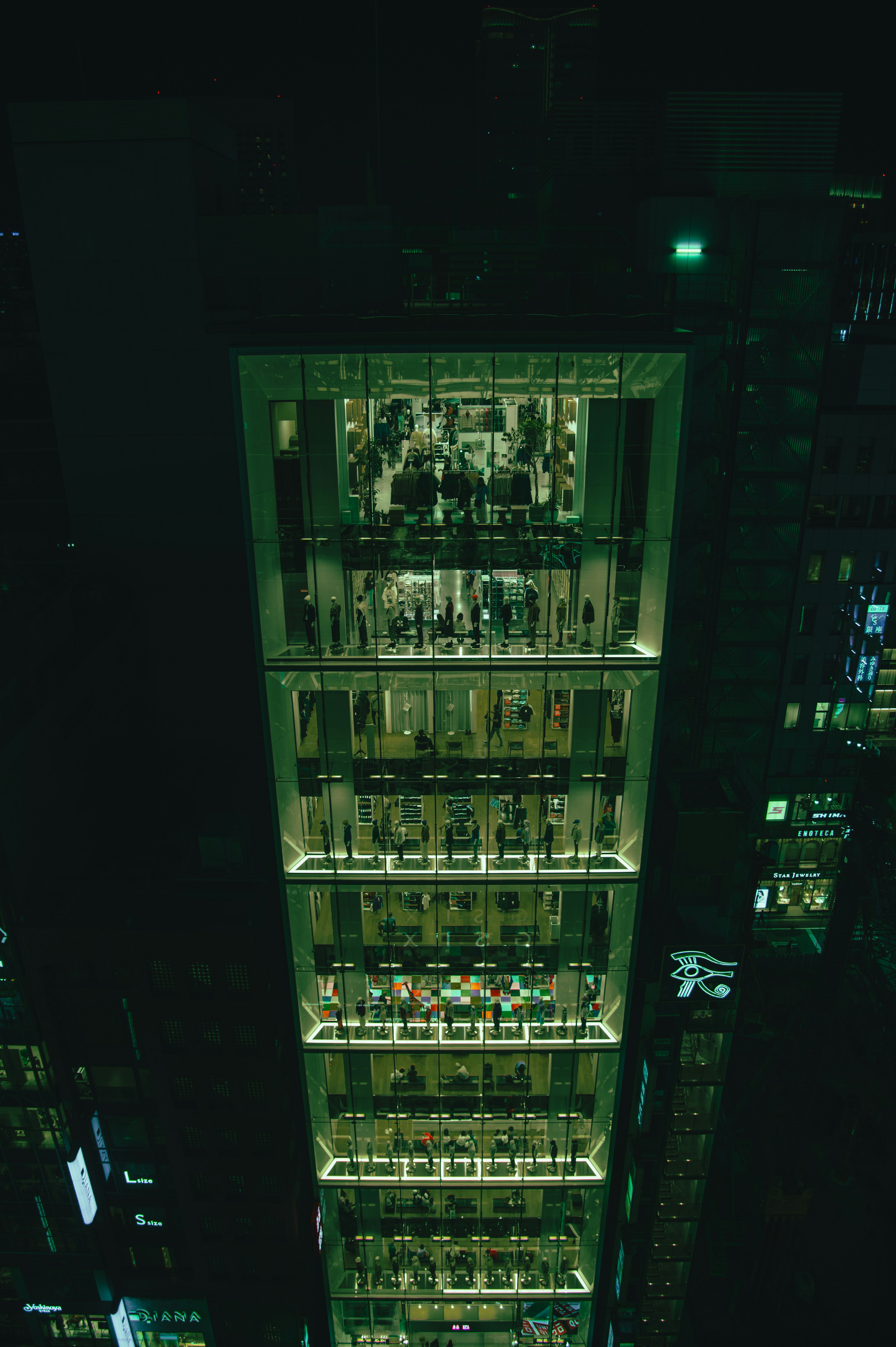 Blick auf ein Einkaufszentrum in einem beleuchteten Hochhaus bei Nacht