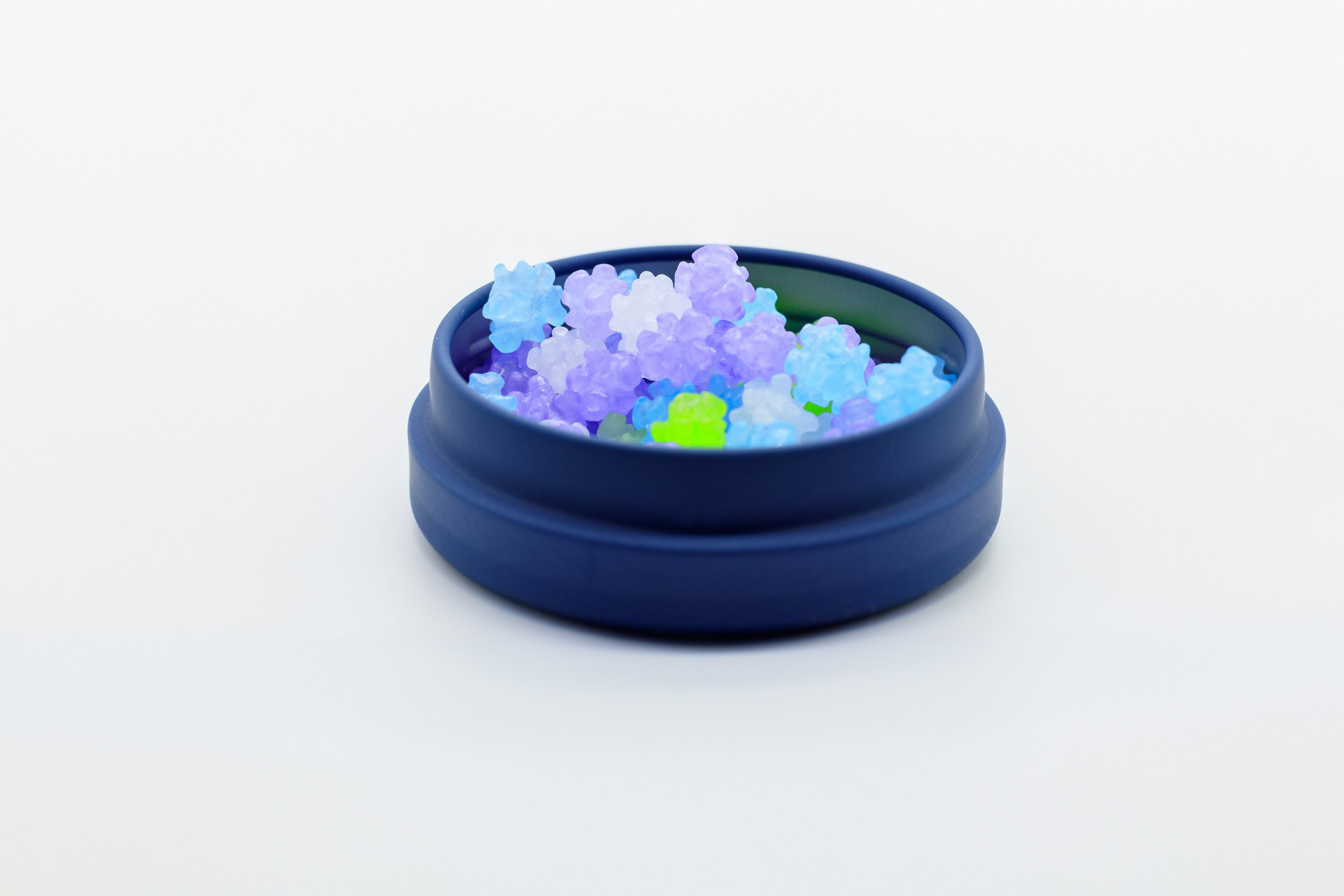 A blue dish filled with small crystals in shades of blue and purple