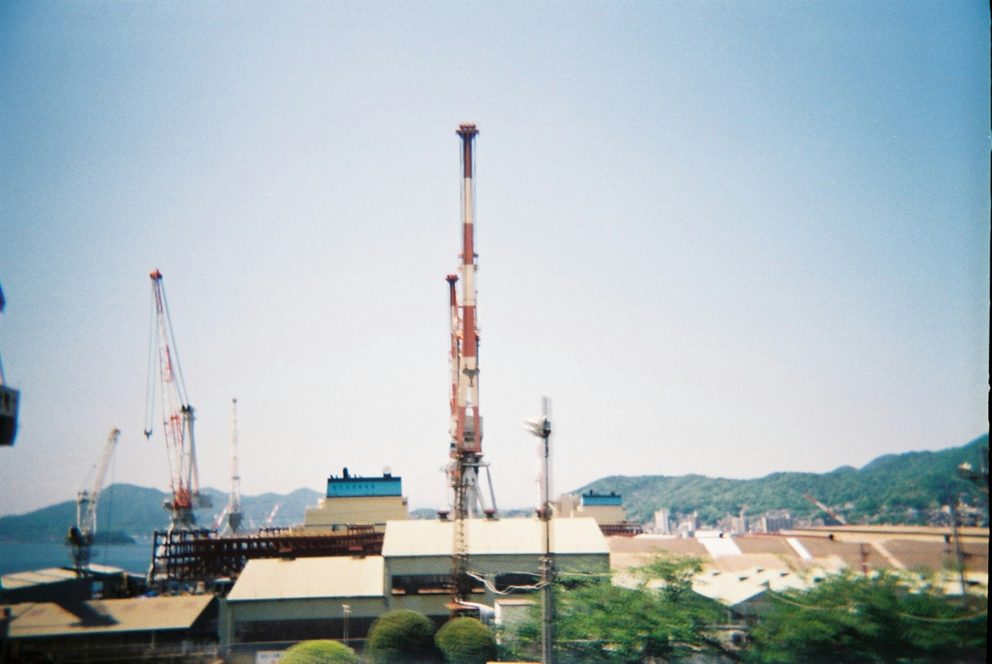 Industrial cranes against a clear blue sky