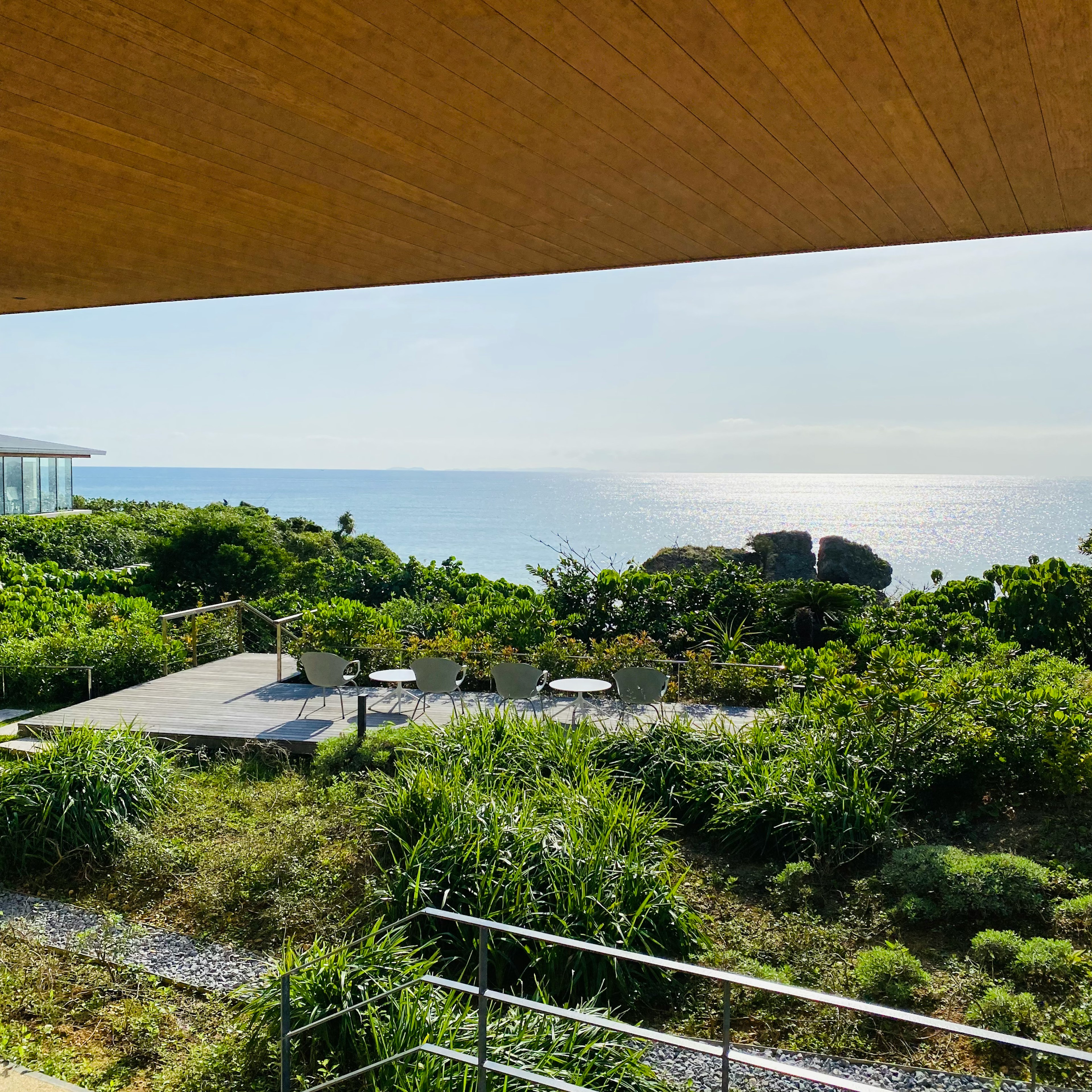 Aussicht von einer Terrasse auf üppiges Grün und den Ozean