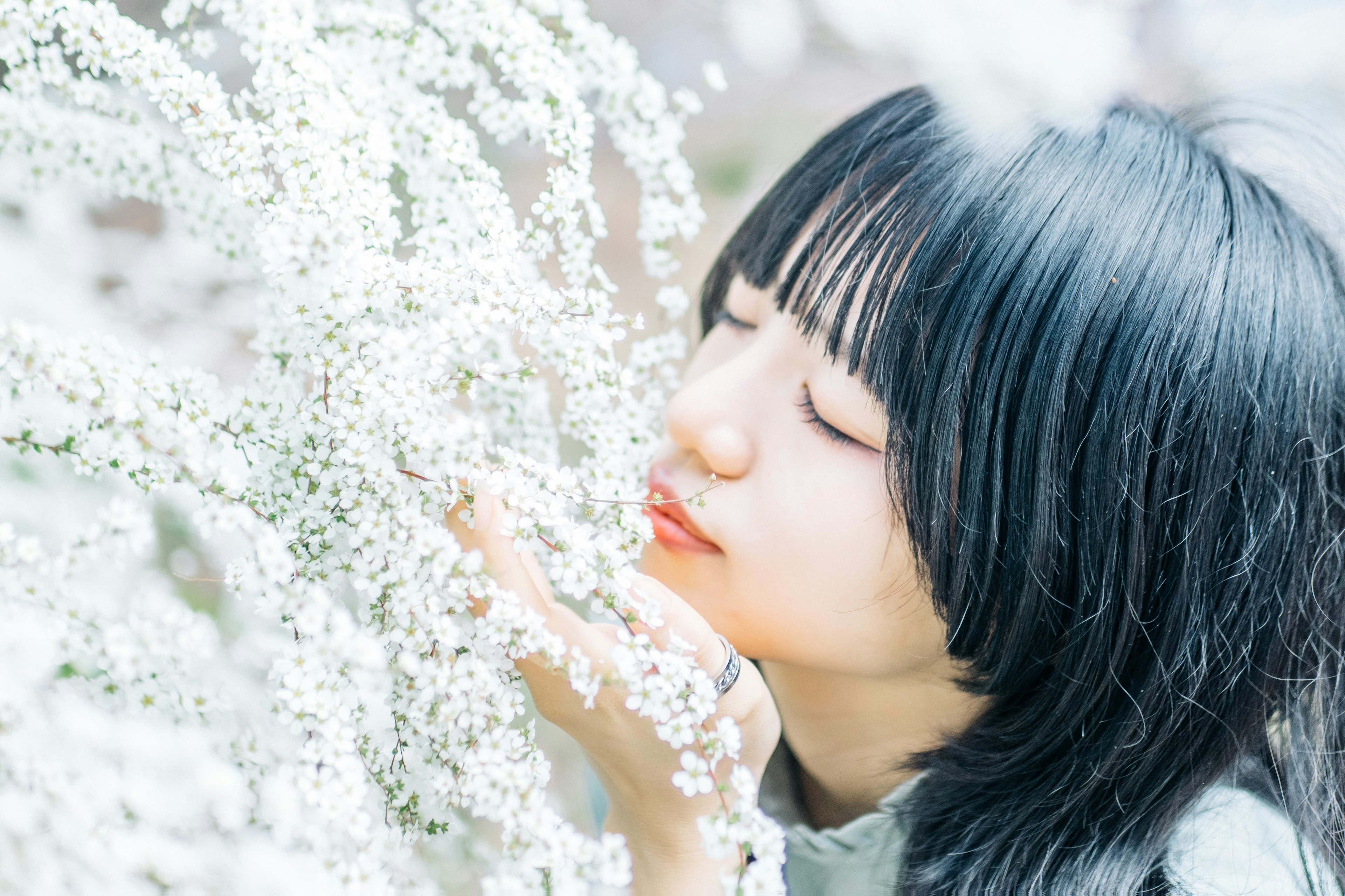 Profil einer Frau, die sanft weiße Blumen berührt