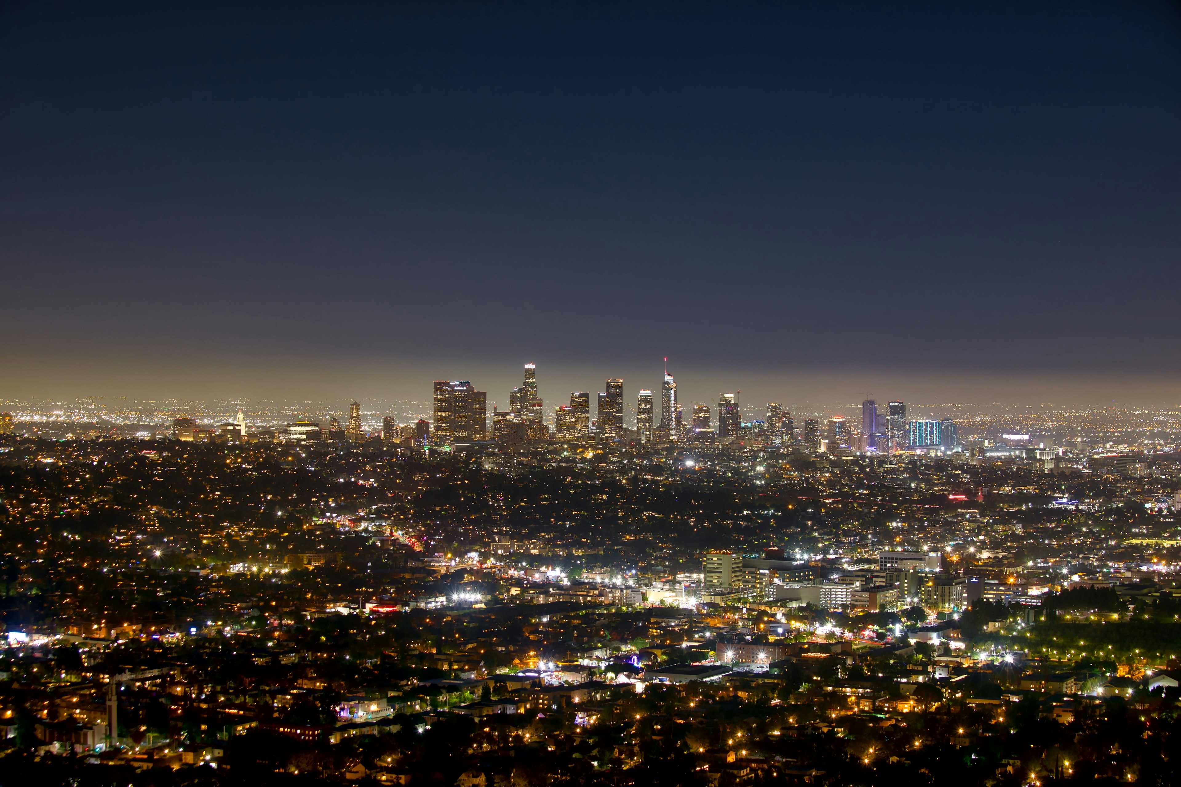 Vista nocturna del horizonte de Los Ángeles iluminado por las luces de la ciudad