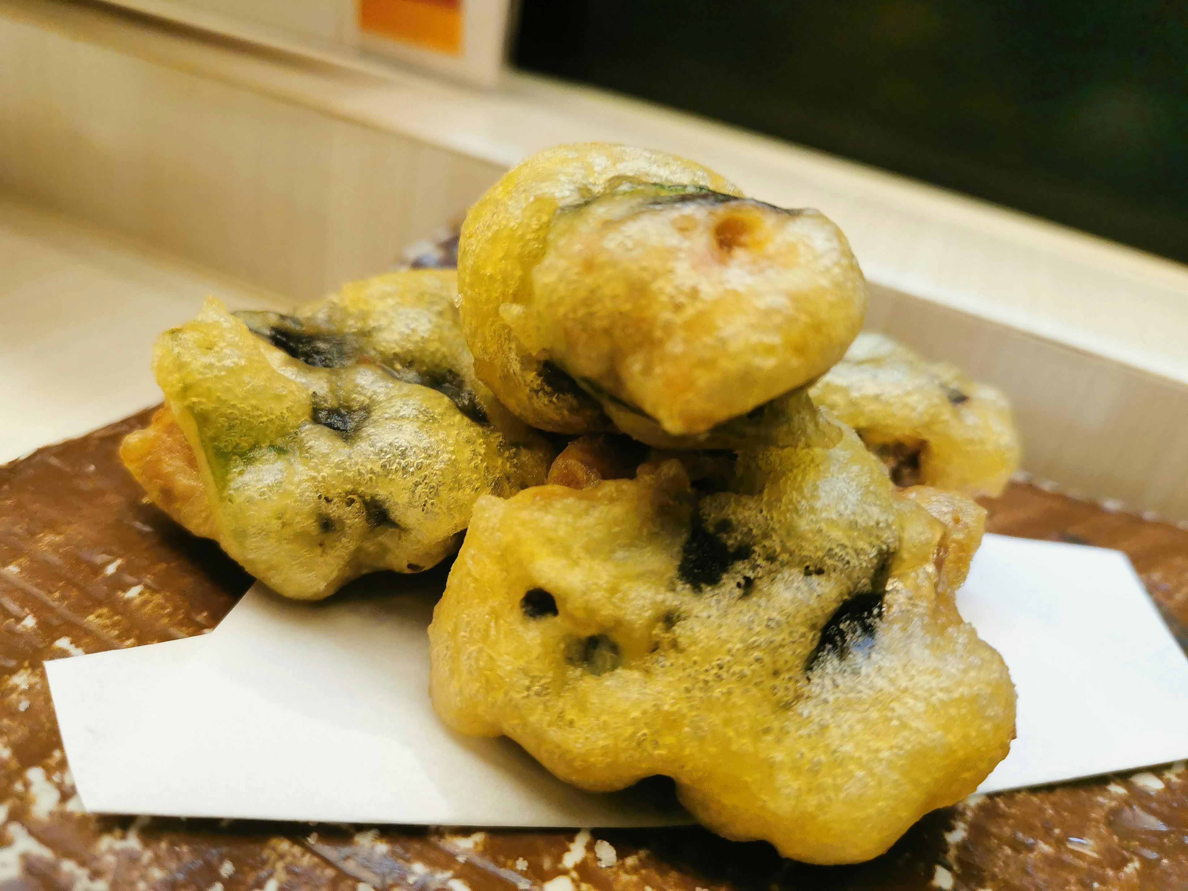 Fried seaweed tempura stacked on a plate