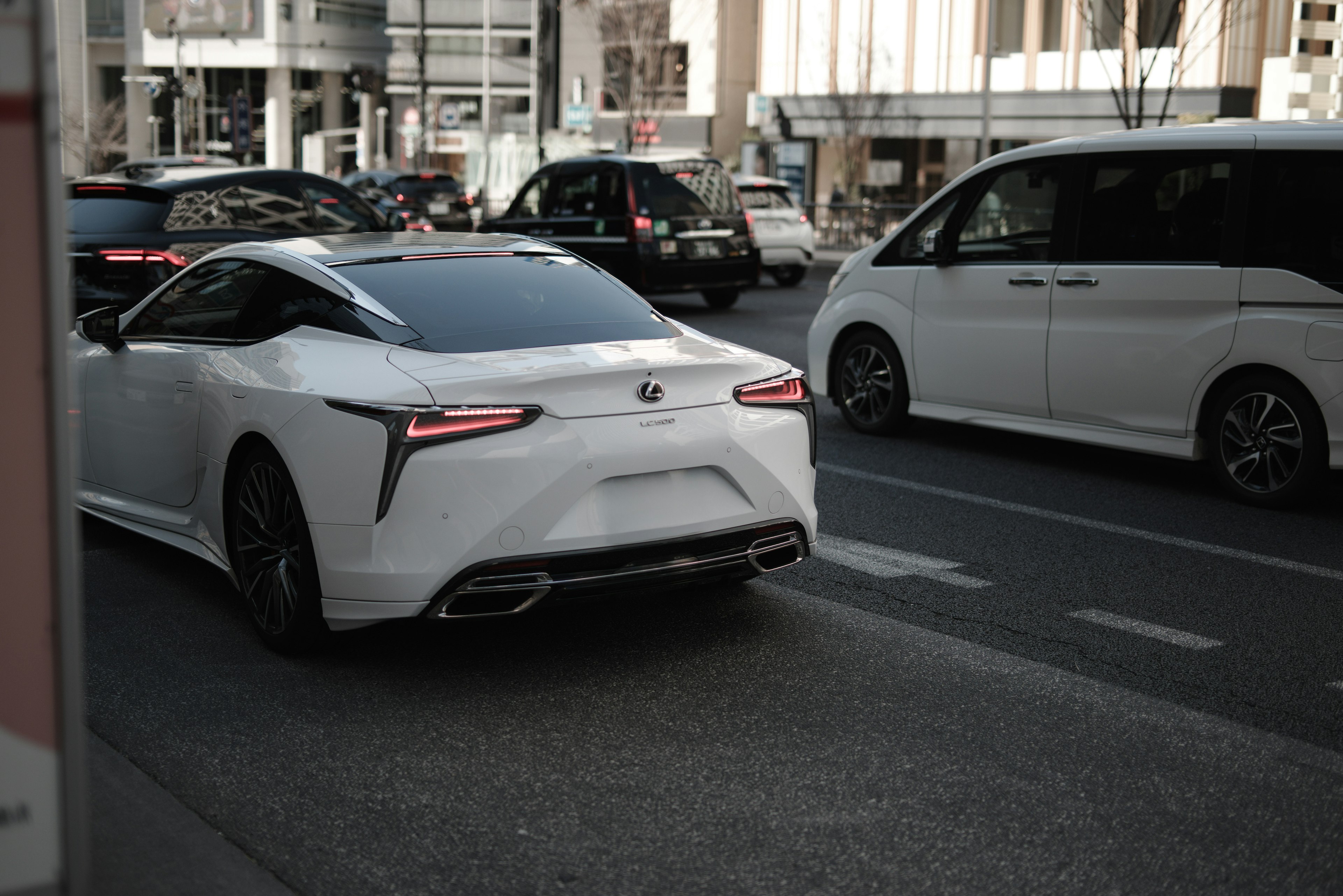 A luxury white car driving on an urban road