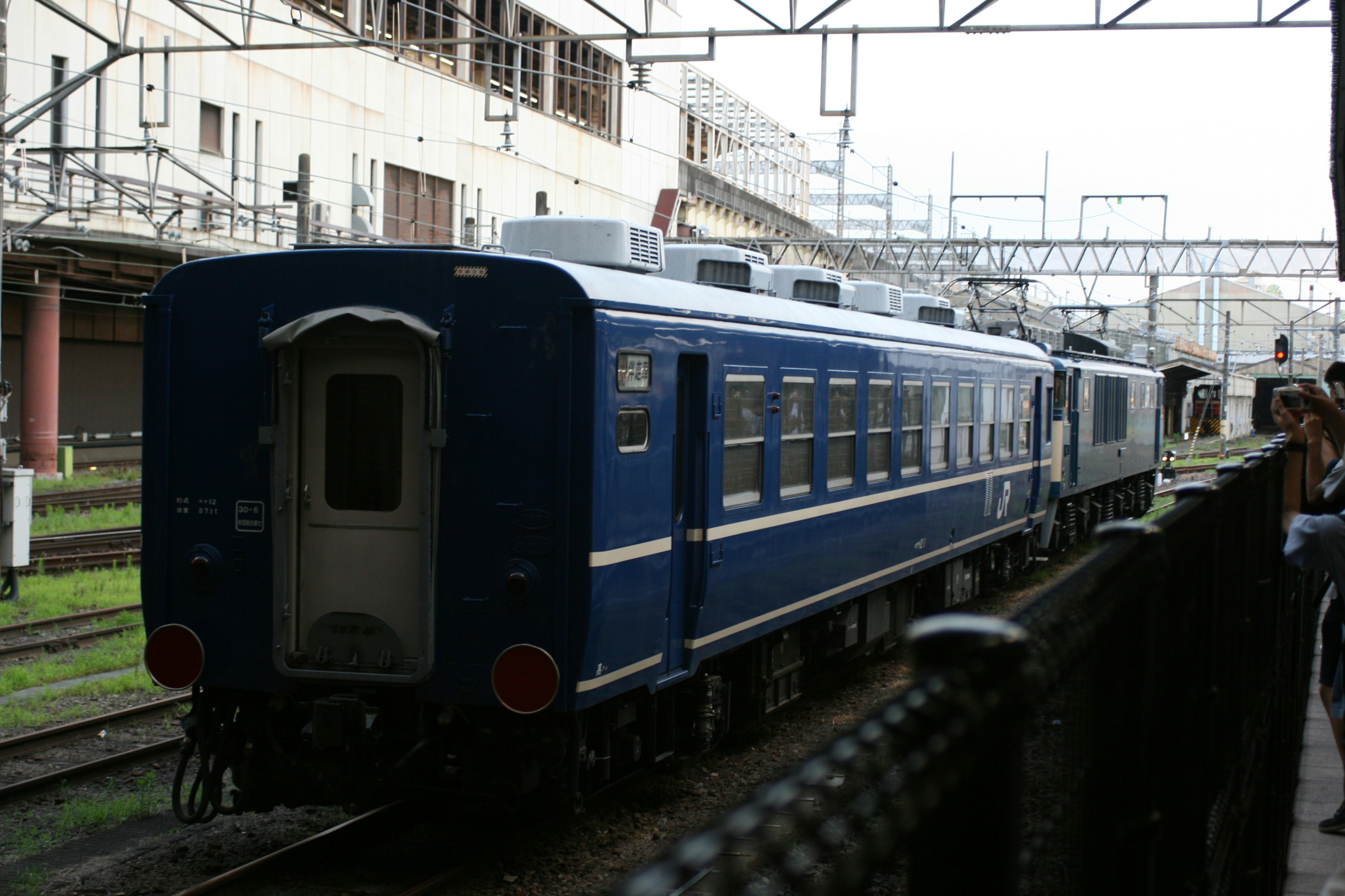 Vagón de tren azul estacionado en una estación