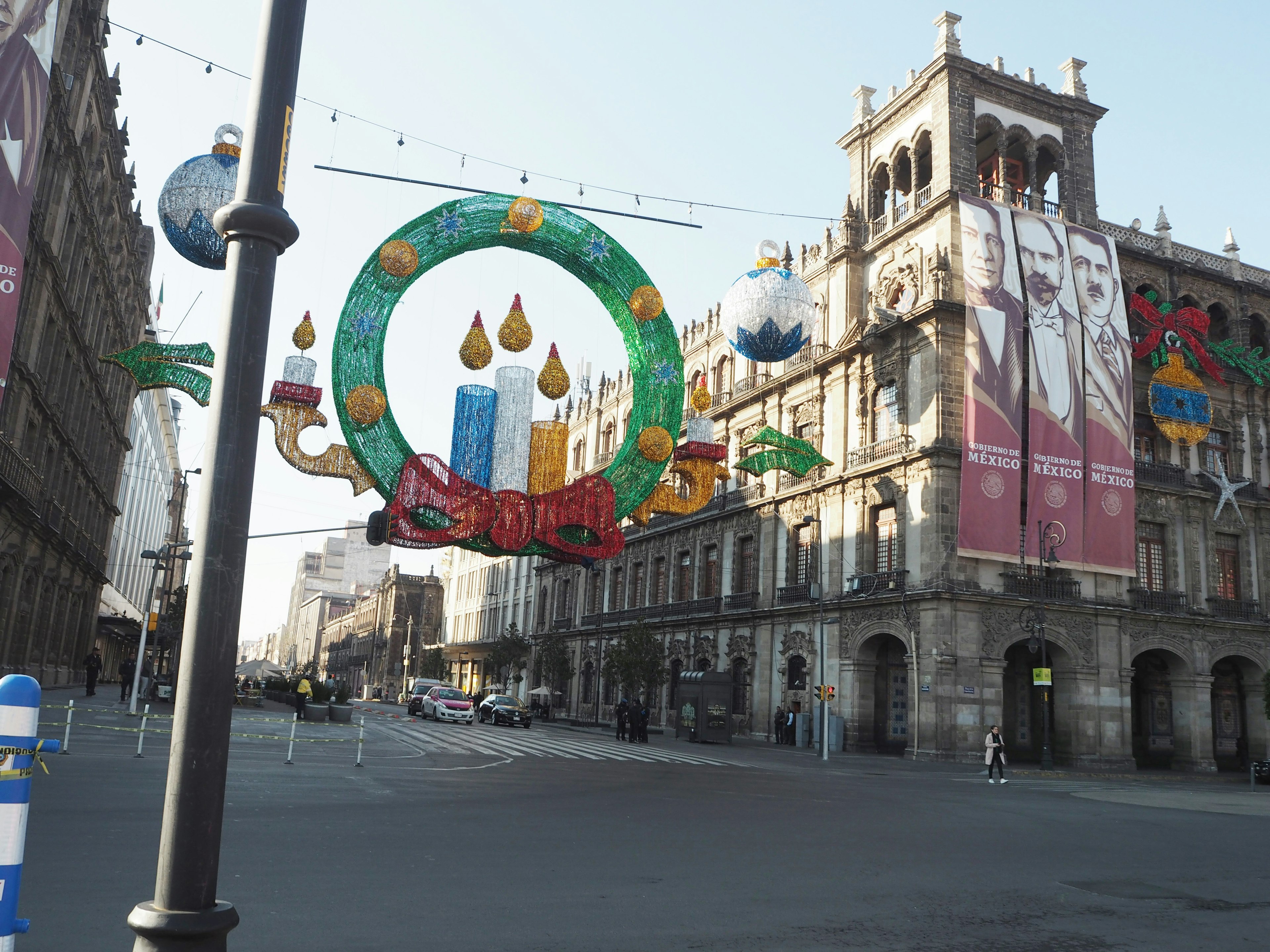 Decoraciones navideñas coloridas frente a un edificio histórico en la Ciudad de México