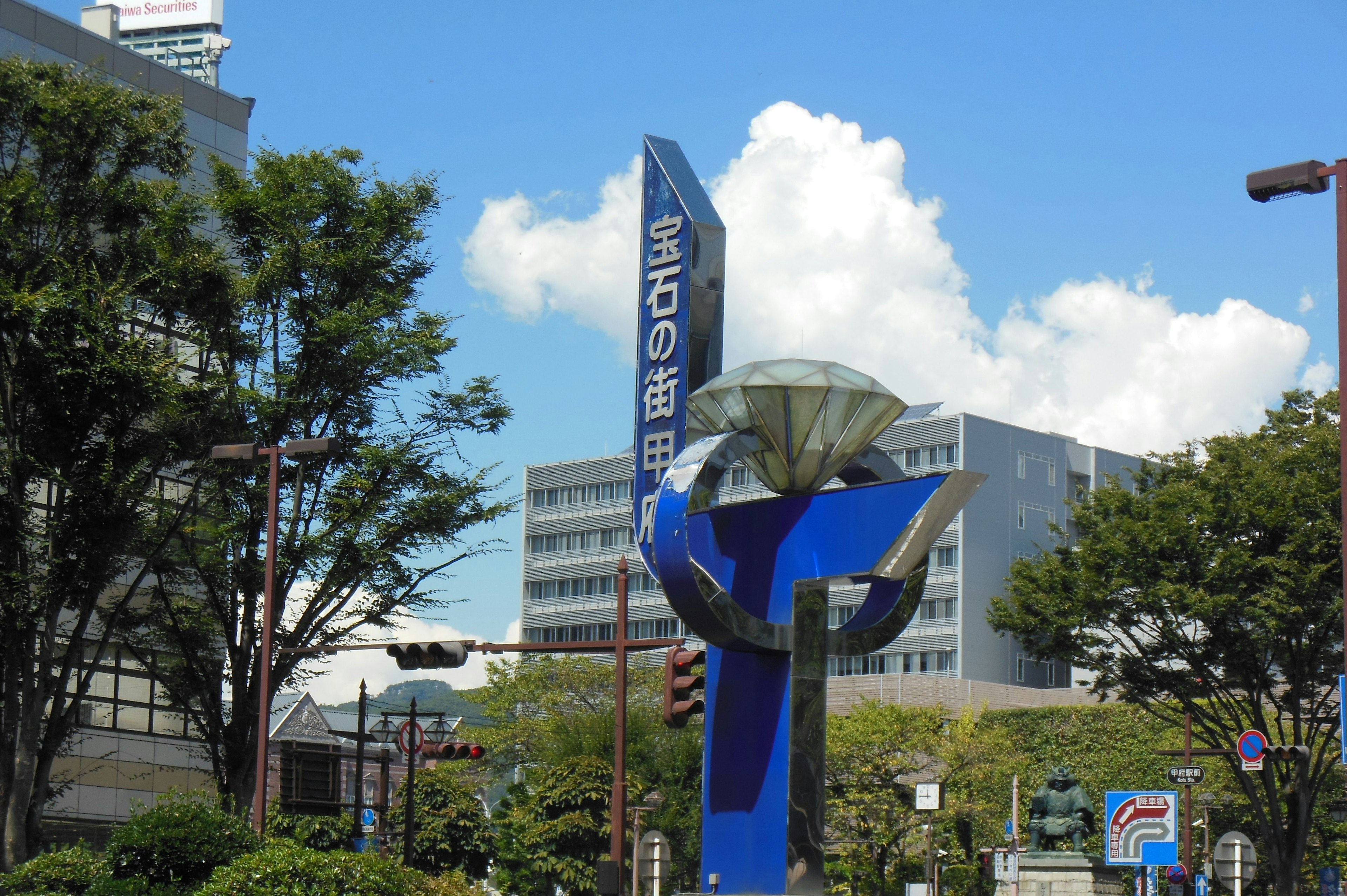 Escultura azul con edificios modernos en un parque