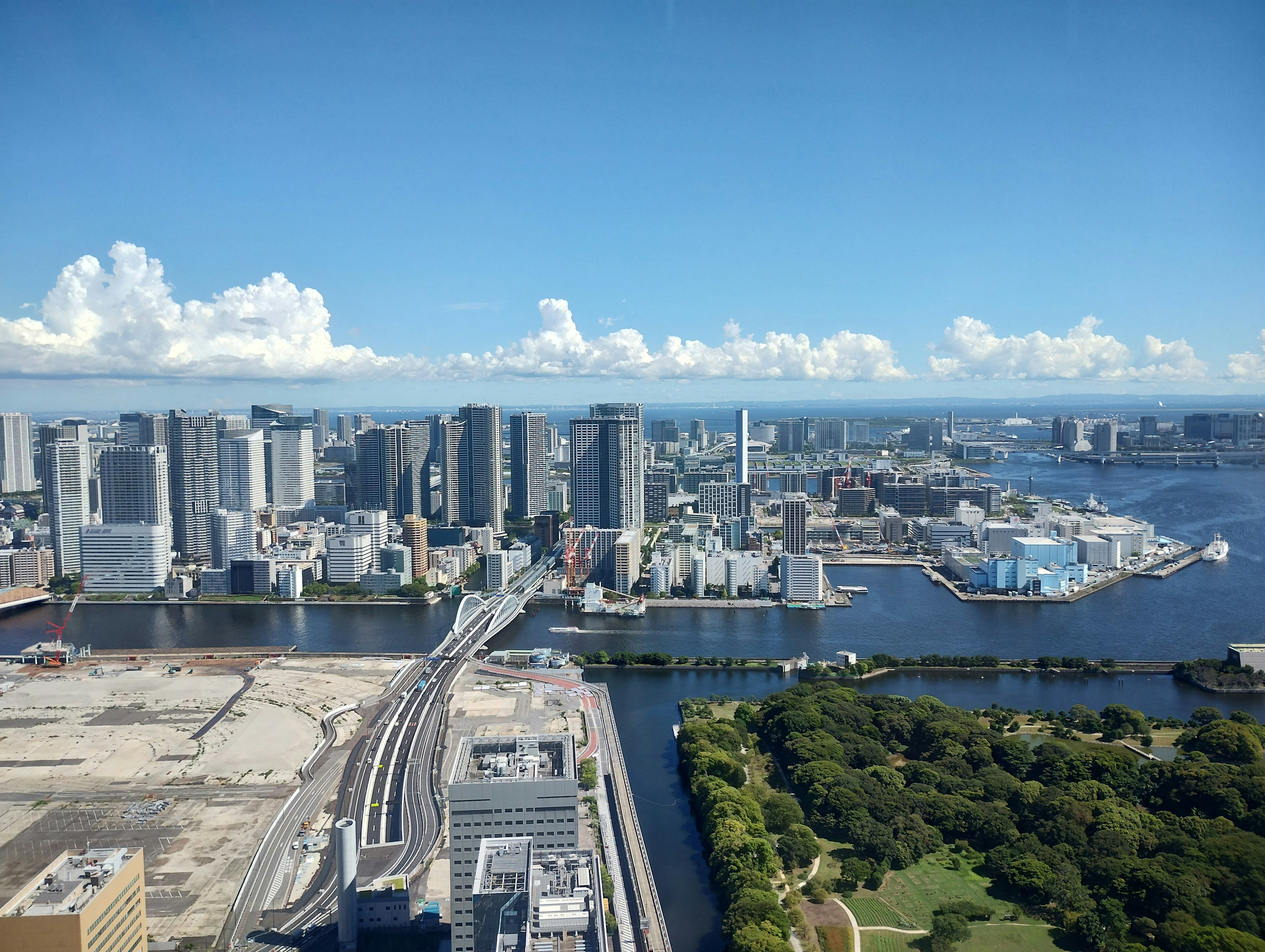 City skyline with high-rise buildings and river under blue sky