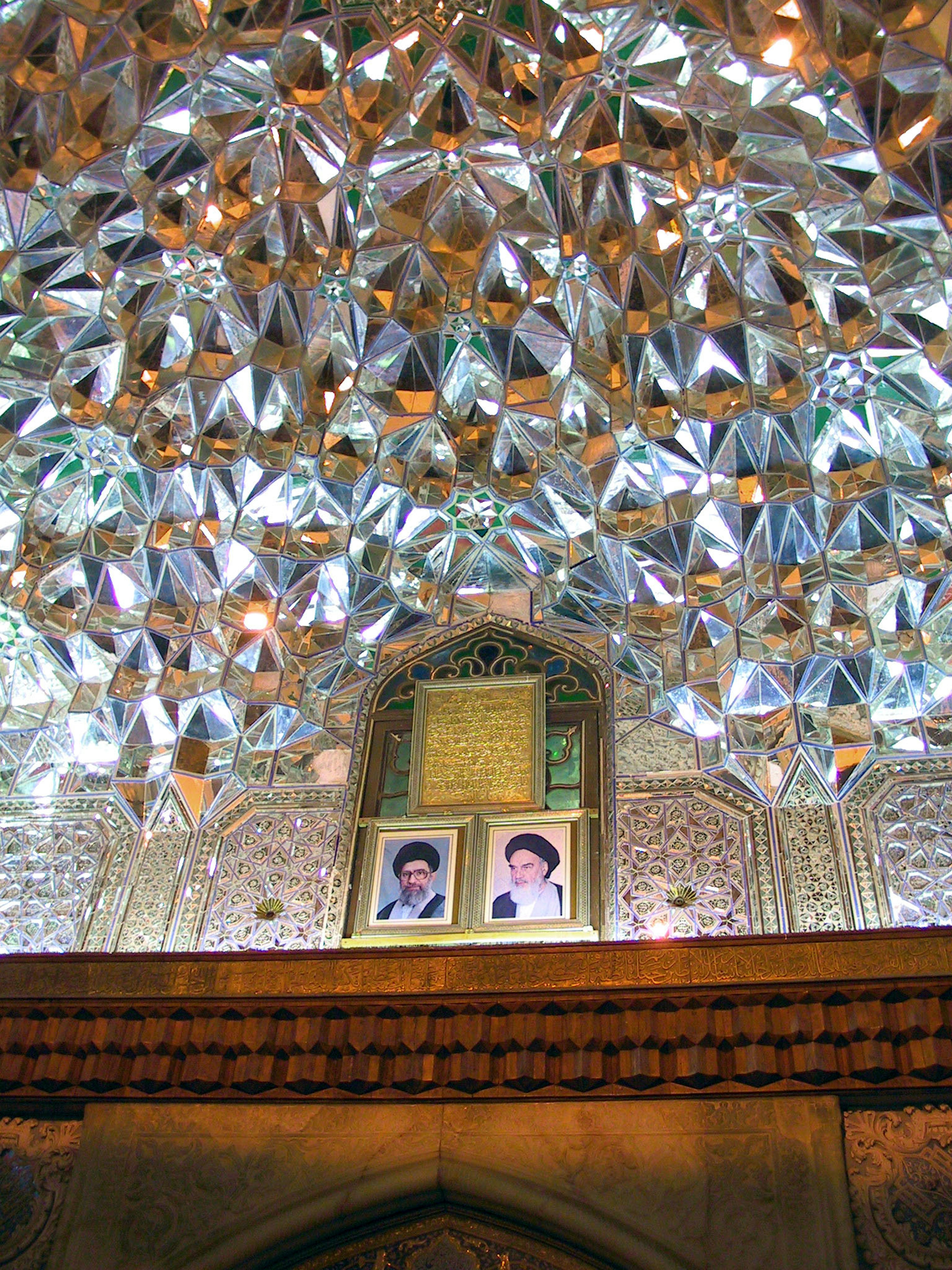 Intricate mirror ceiling with two portraits below