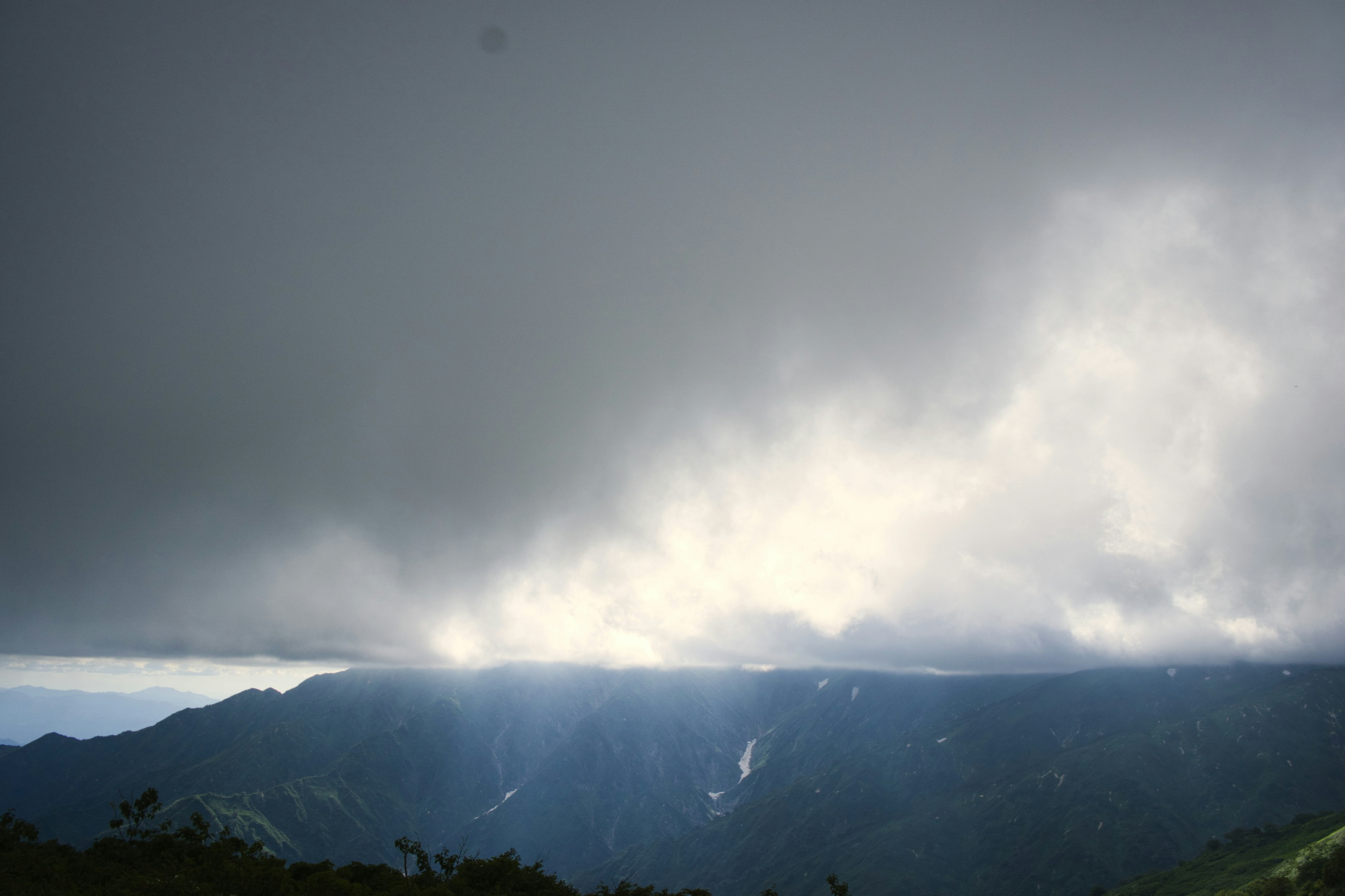 Pemandangan pegunungan dengan awan dan cahaya yang menembus