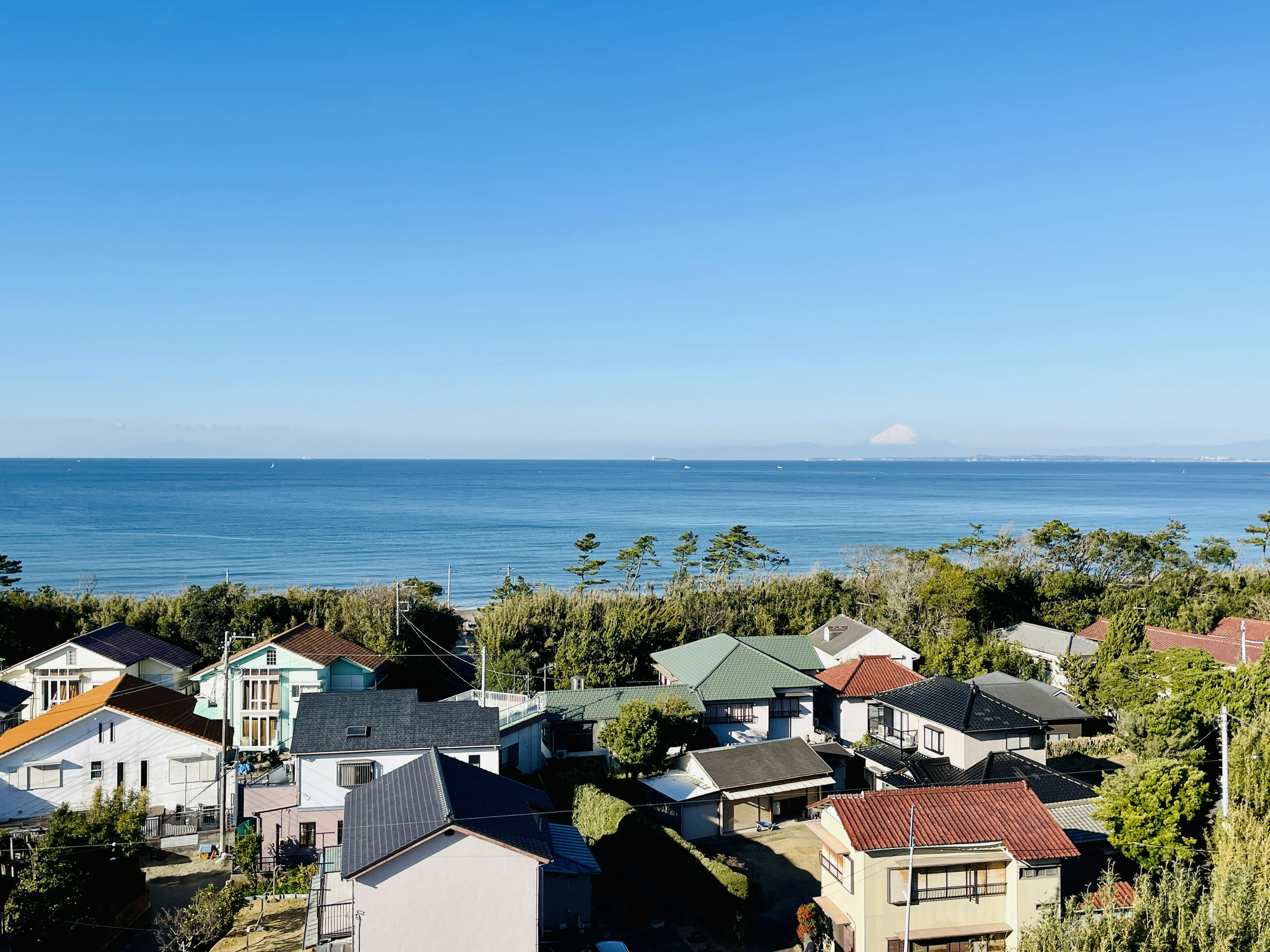 A panoramic view of houses overlooking the sea under a clear blue sky