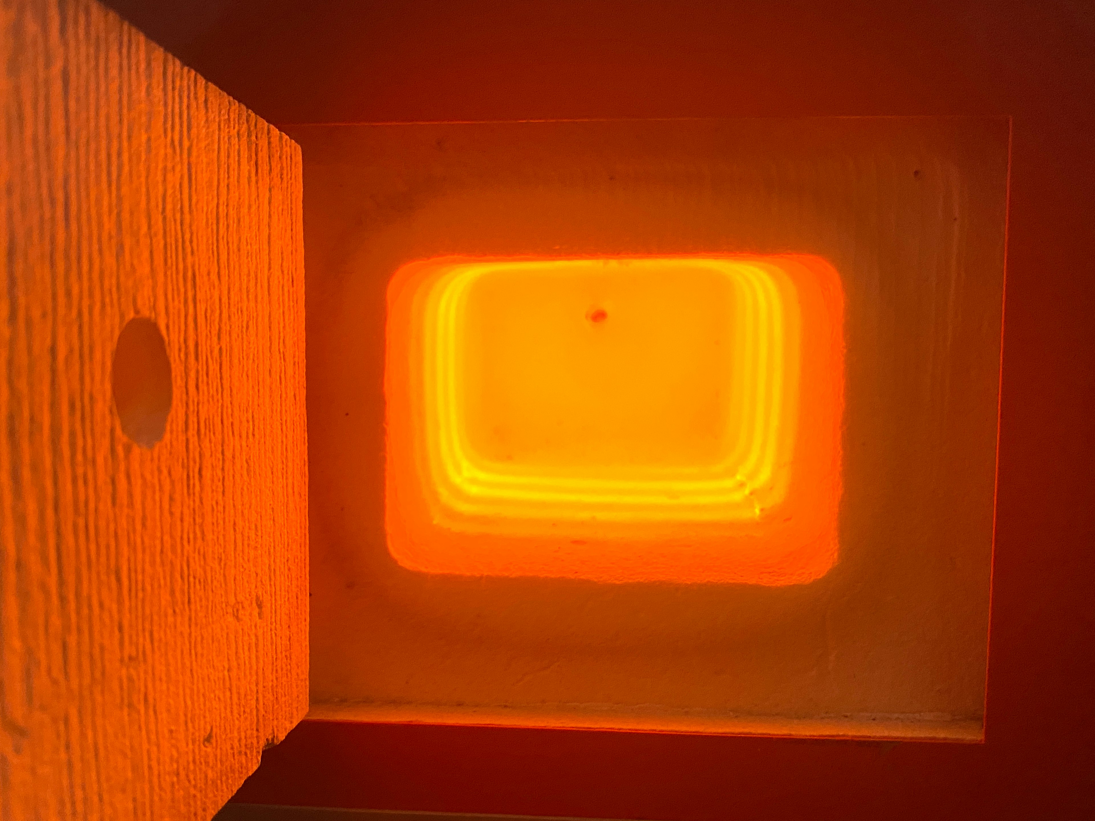 Warm orange light emanating from inside a wooden box