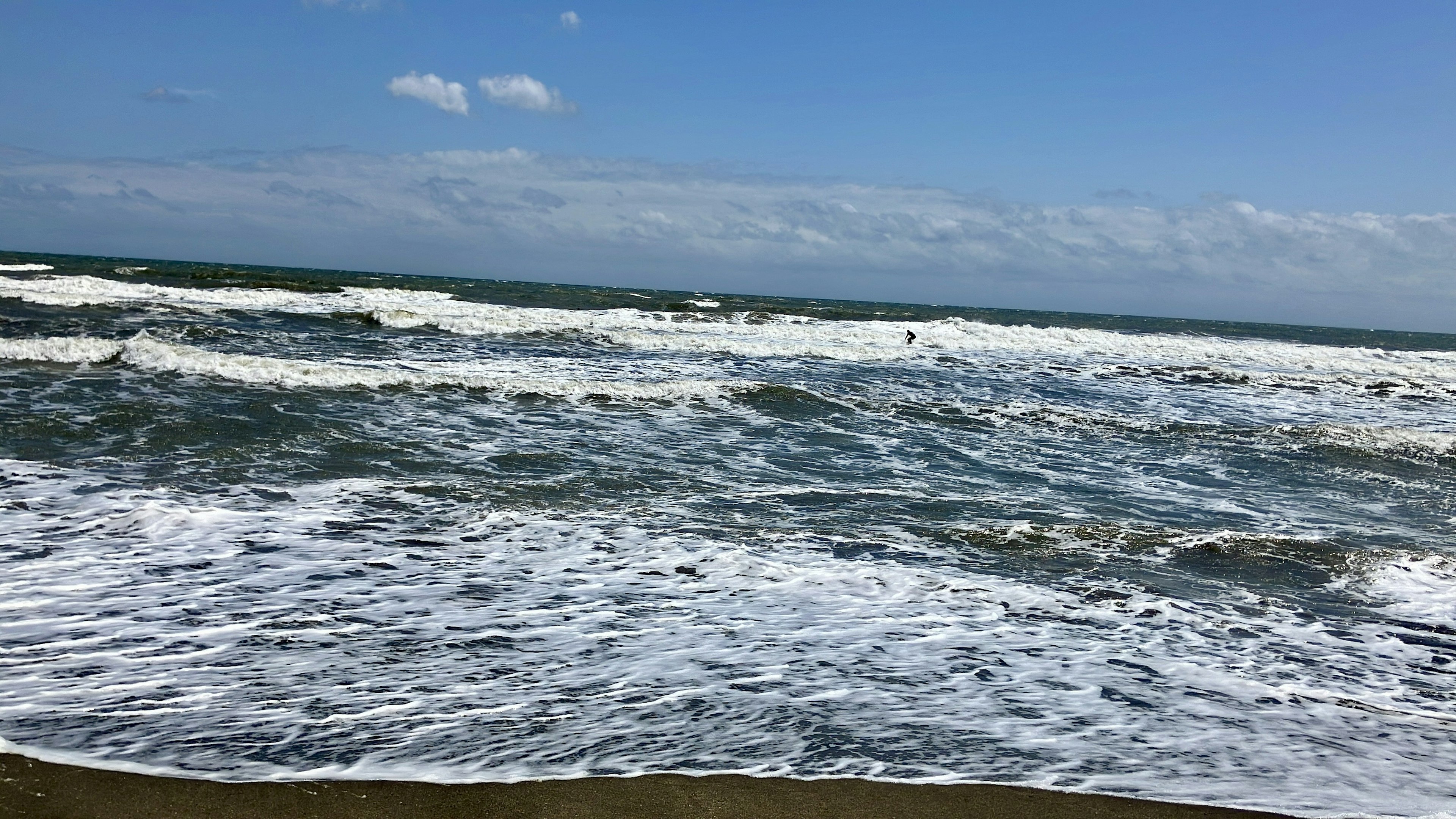 Pemandangan lautan biru dengan ombak menghantam pantai