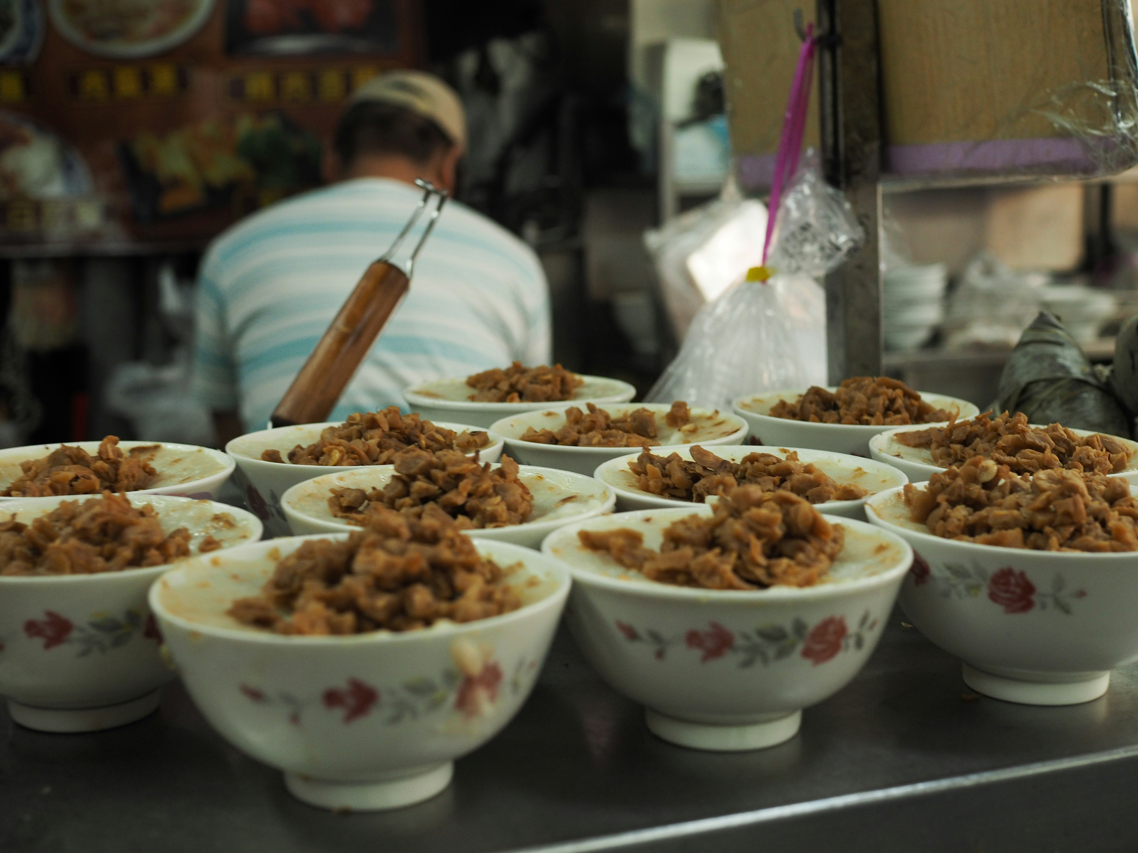 Plusieurs bols remplis d'un plat et un cuisinier en arrière-plan