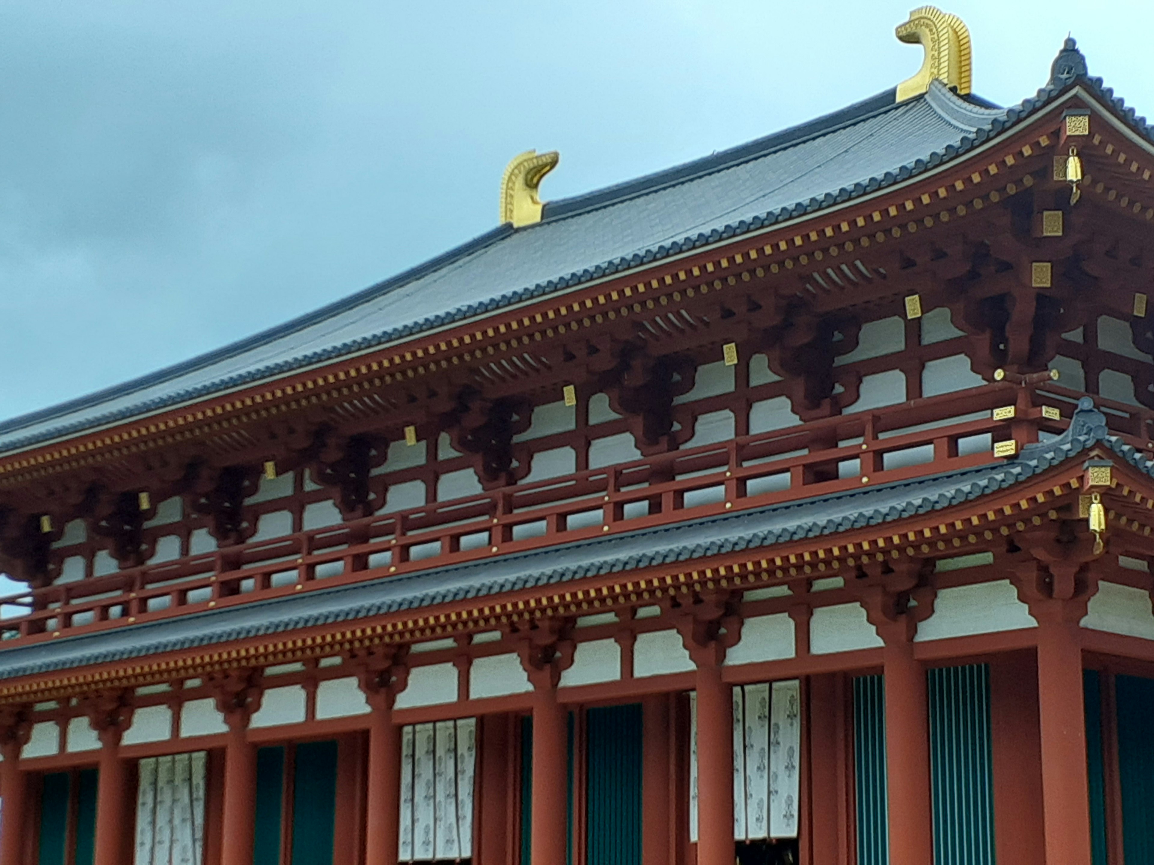 传统日本建筑，屋顶上有美丽的红色柱子和金色装饰