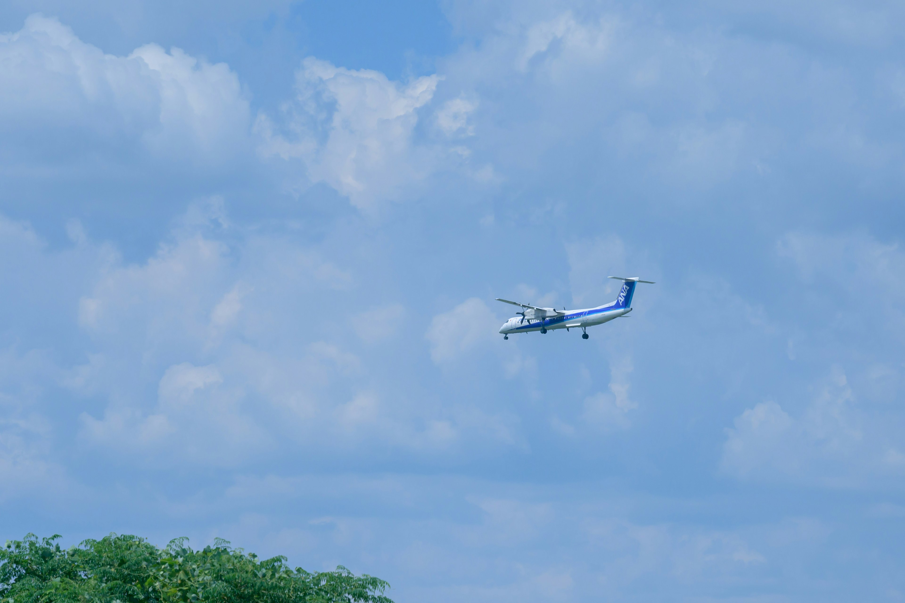 Piccolo aereo che vola in un cielo blu con nuvole bianche