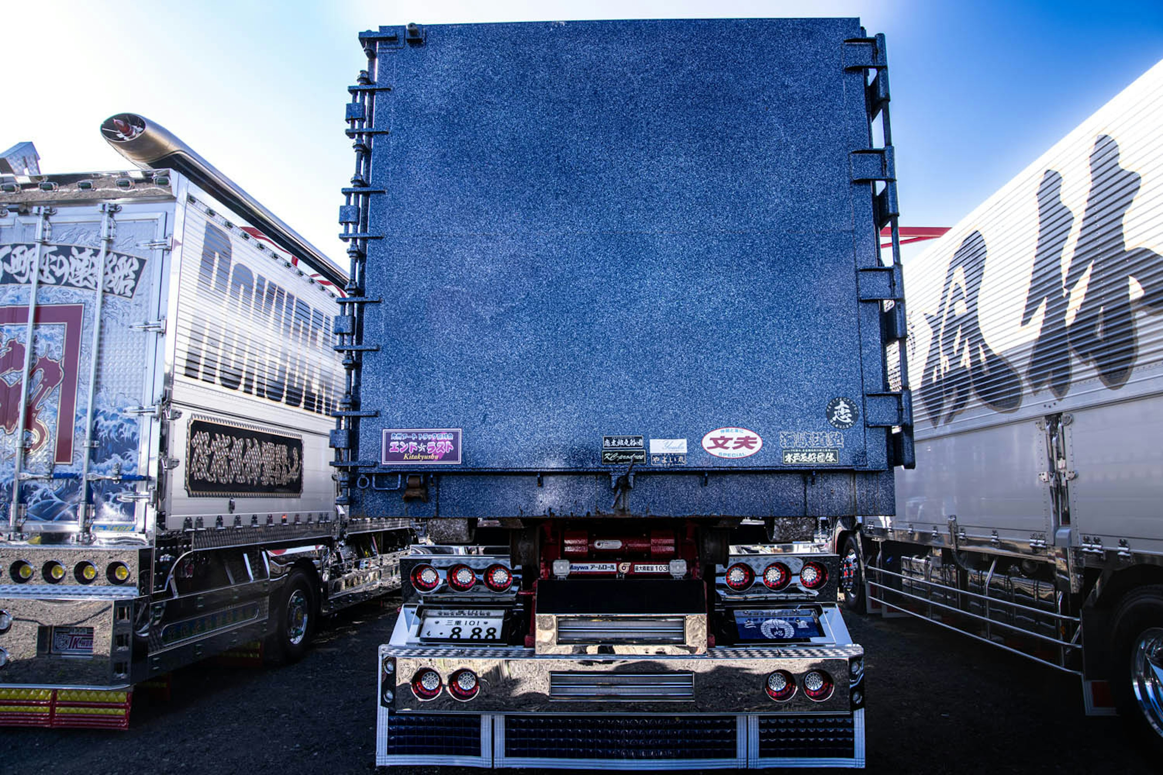 Vue arrière d'un camion bleu garé parmi d'autres camions