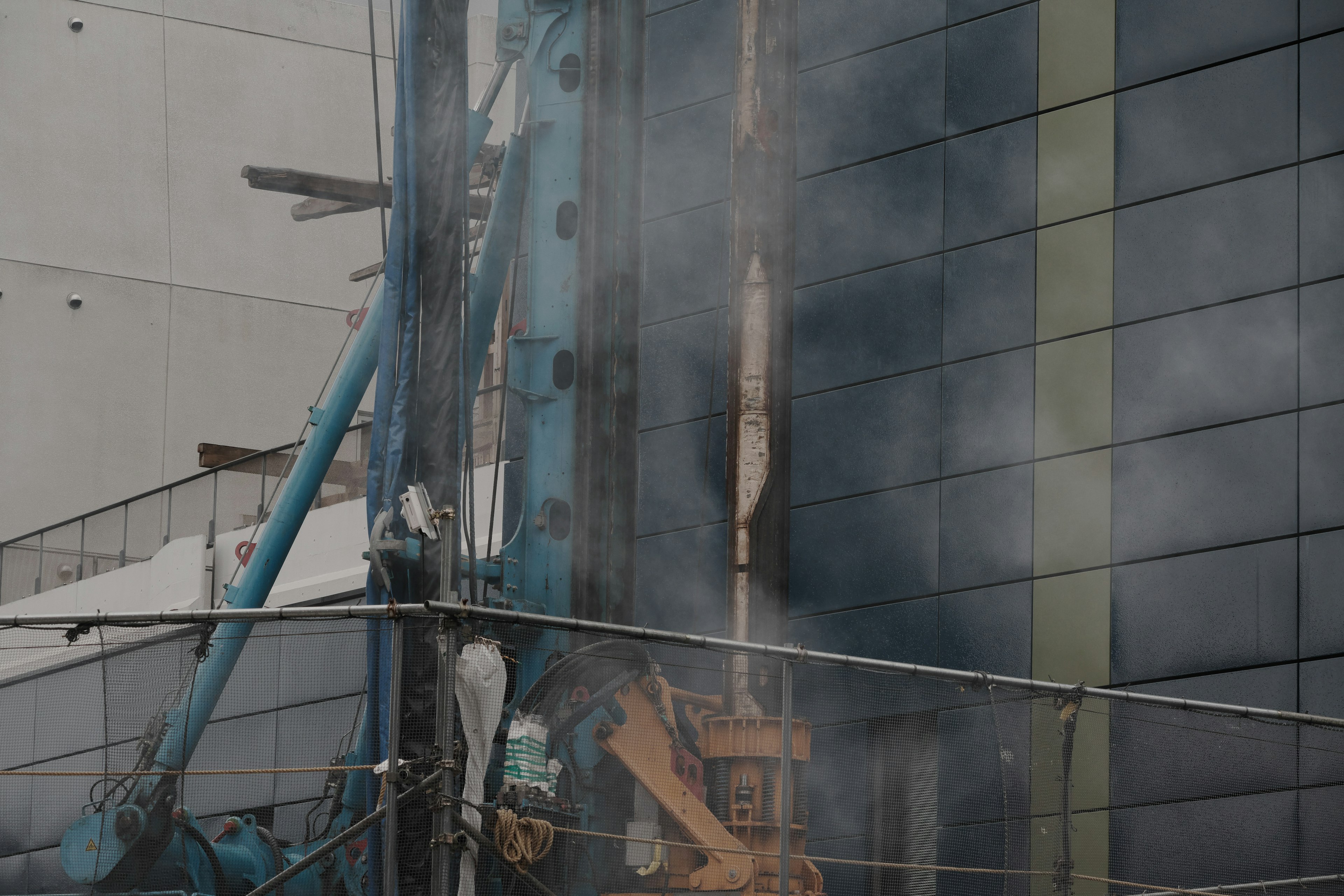 Construction site featuring a crane and visible smoke